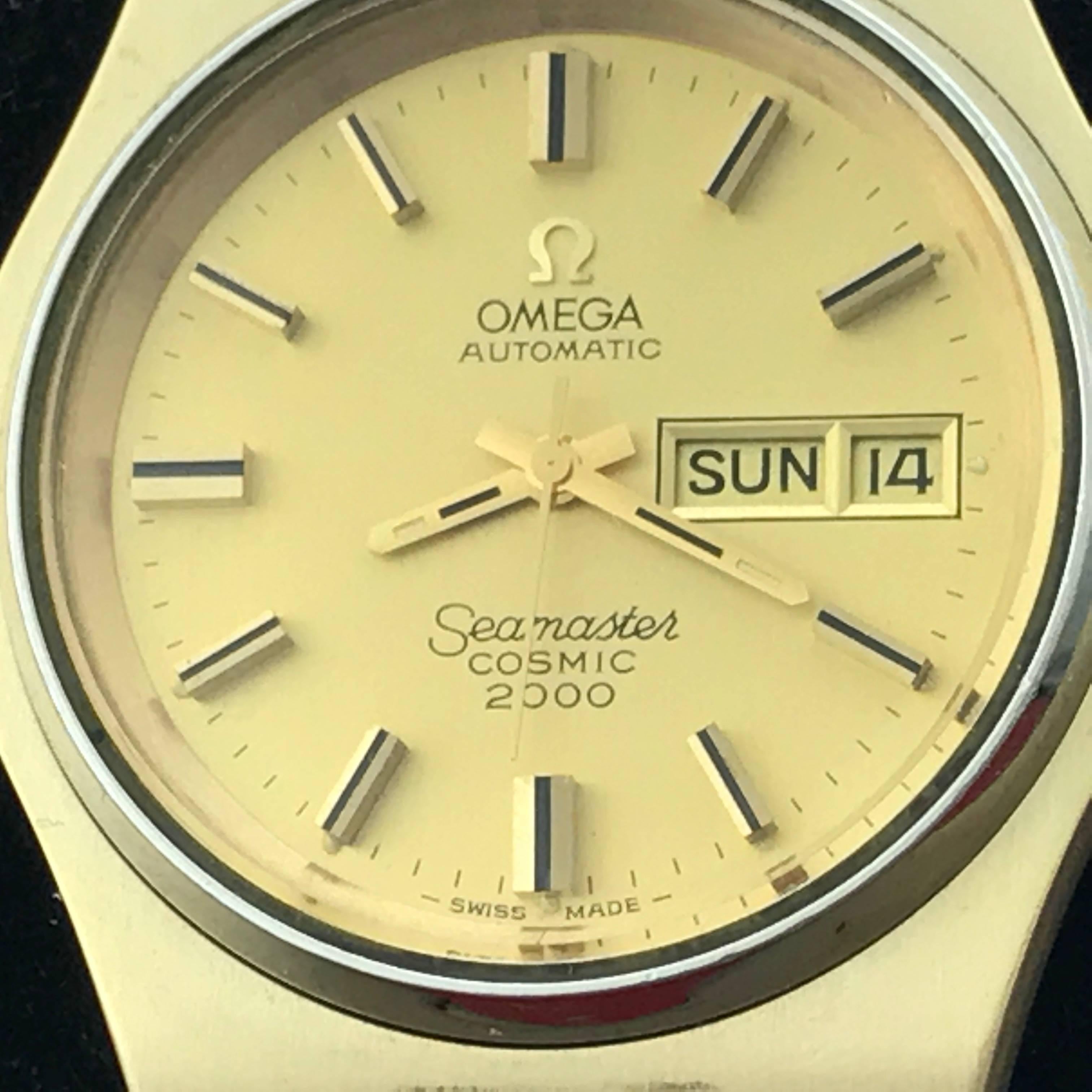 Omega Seamaster Cosmic 2000 Yellow Gold and Stainless Steel Day Date Automatic Wristwatch. Champagne Dial with yellow gold and black hour markers. Yellow gold over Stainless Steel case with (43mm dia.) Yellow gold over stainless steel Omega bracelet