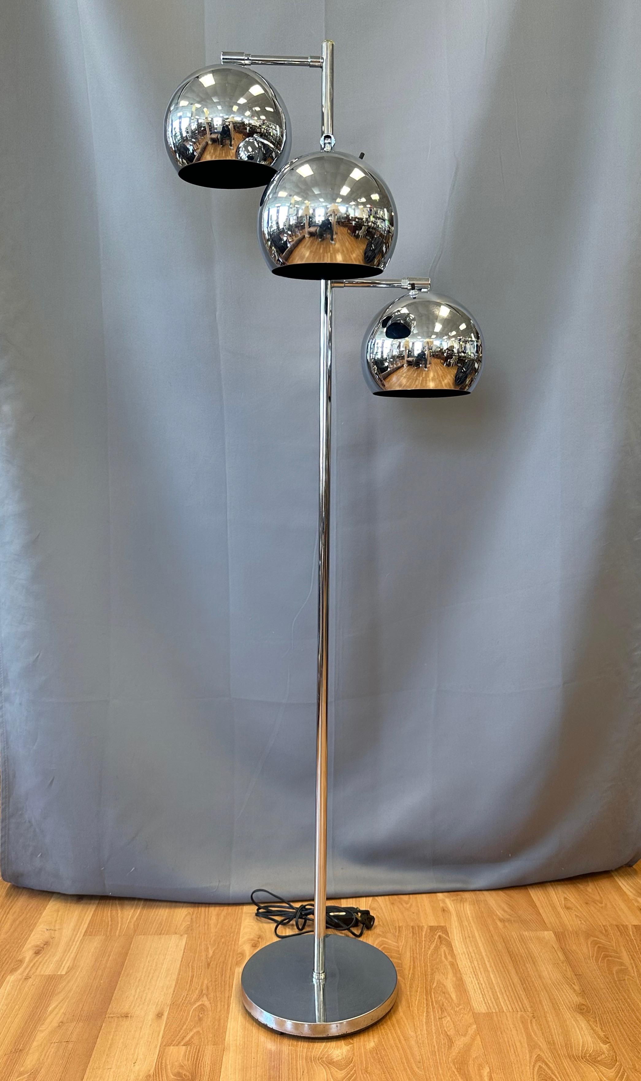 A late 1960s chrome floor lamp with a trio of articulated orb lights by OMI for Koch & Lowy.

Finished in gleaming chrome from top to bottom. Eyeball-style globe shades with matte black interiors rotate and swivel on fixed arms that branch out in