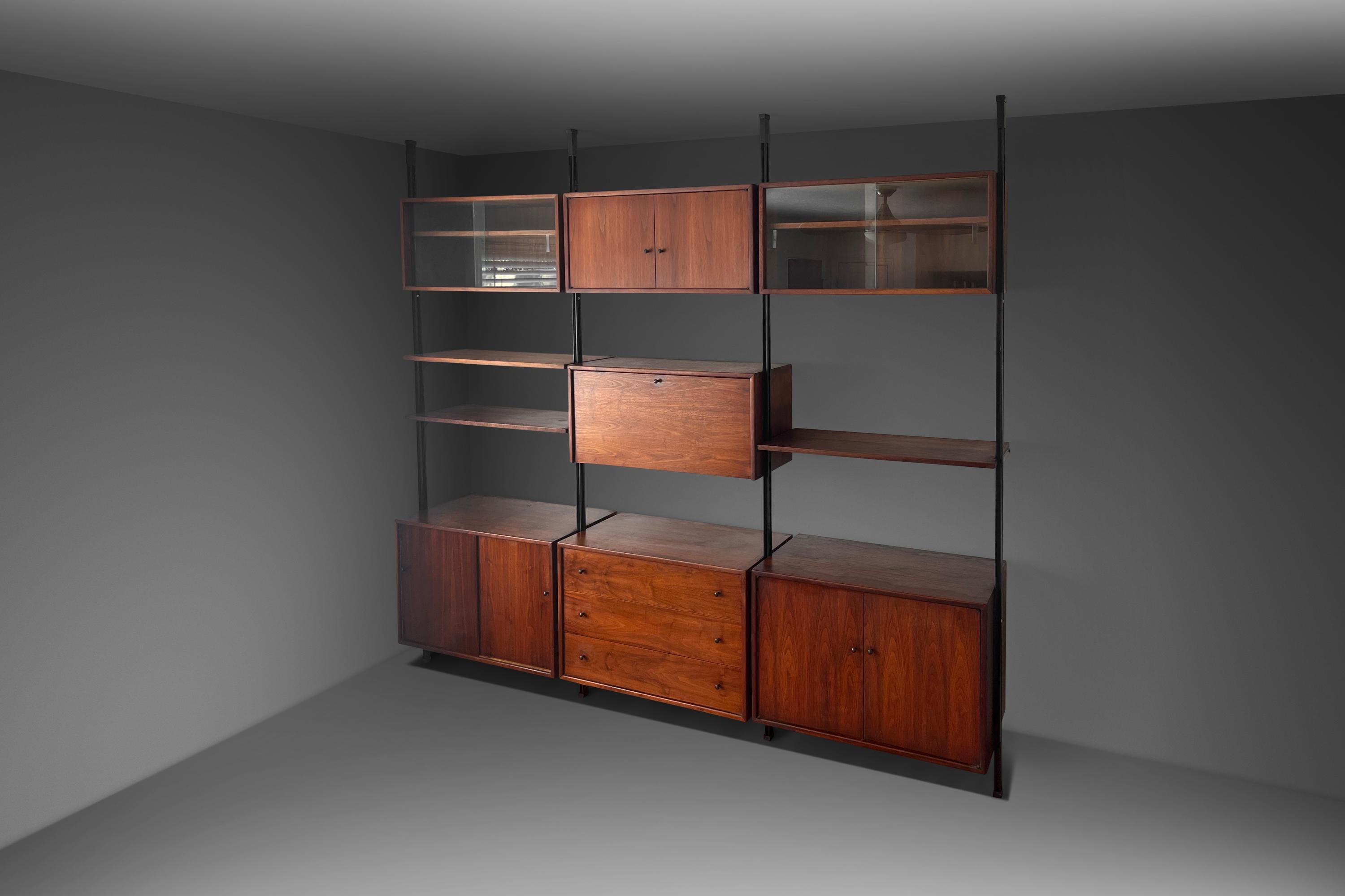 A rare and exceptional wall unit designed with strong influences taken from George Nelson's Omni Wall Unit for Herman Miller. The systems, modular design that can be configured to your taste. The wall unit includes three bottom cabinets, two of