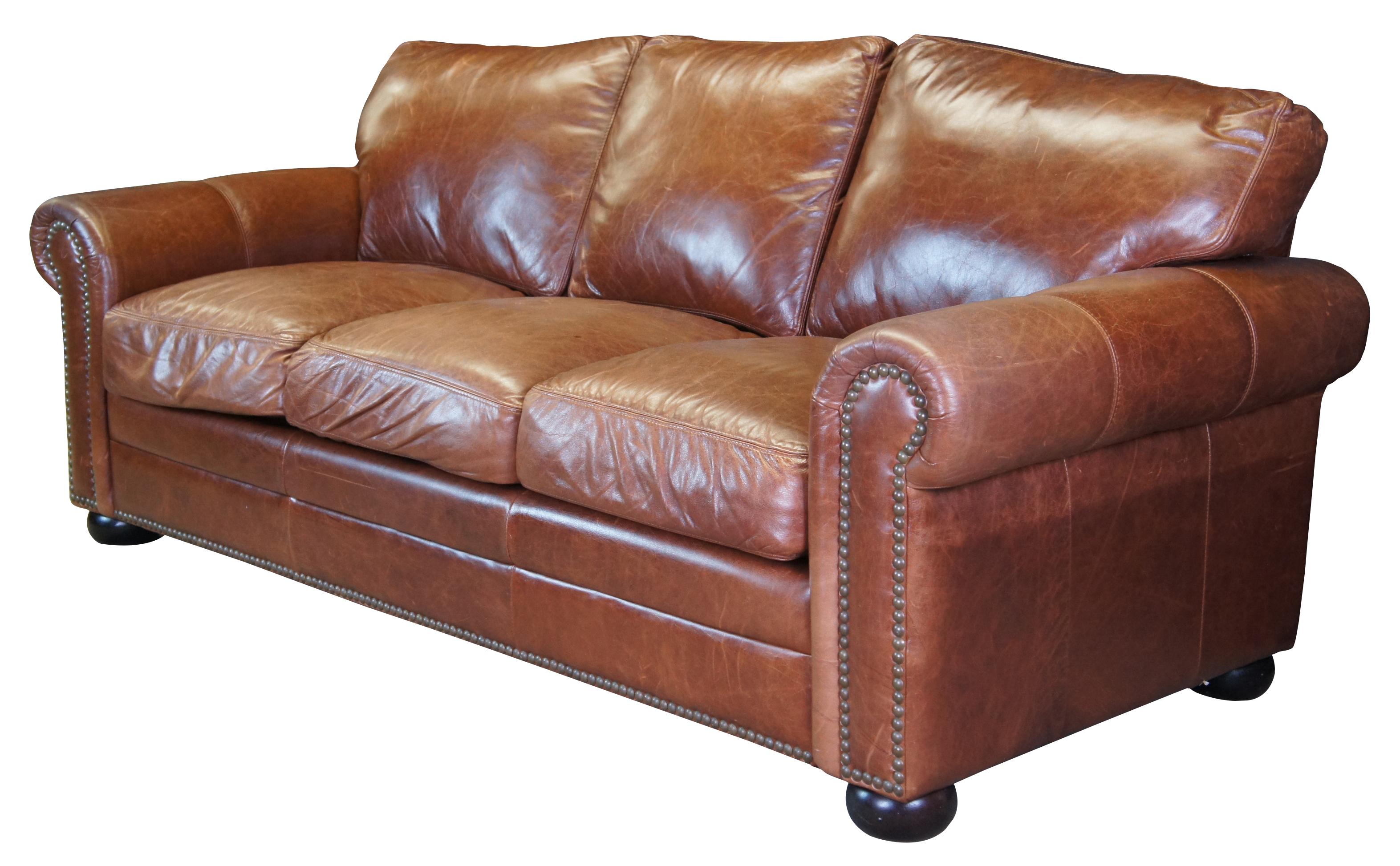 The Omnia Savannah Leather 3 Seat Sofa.  Traditional form with rolled arms and bun feet.  Features individually placed touching nail heads along the front arm panels and along bottom of front panel.  Bun feet finished in Expresso finish.  Ideal for