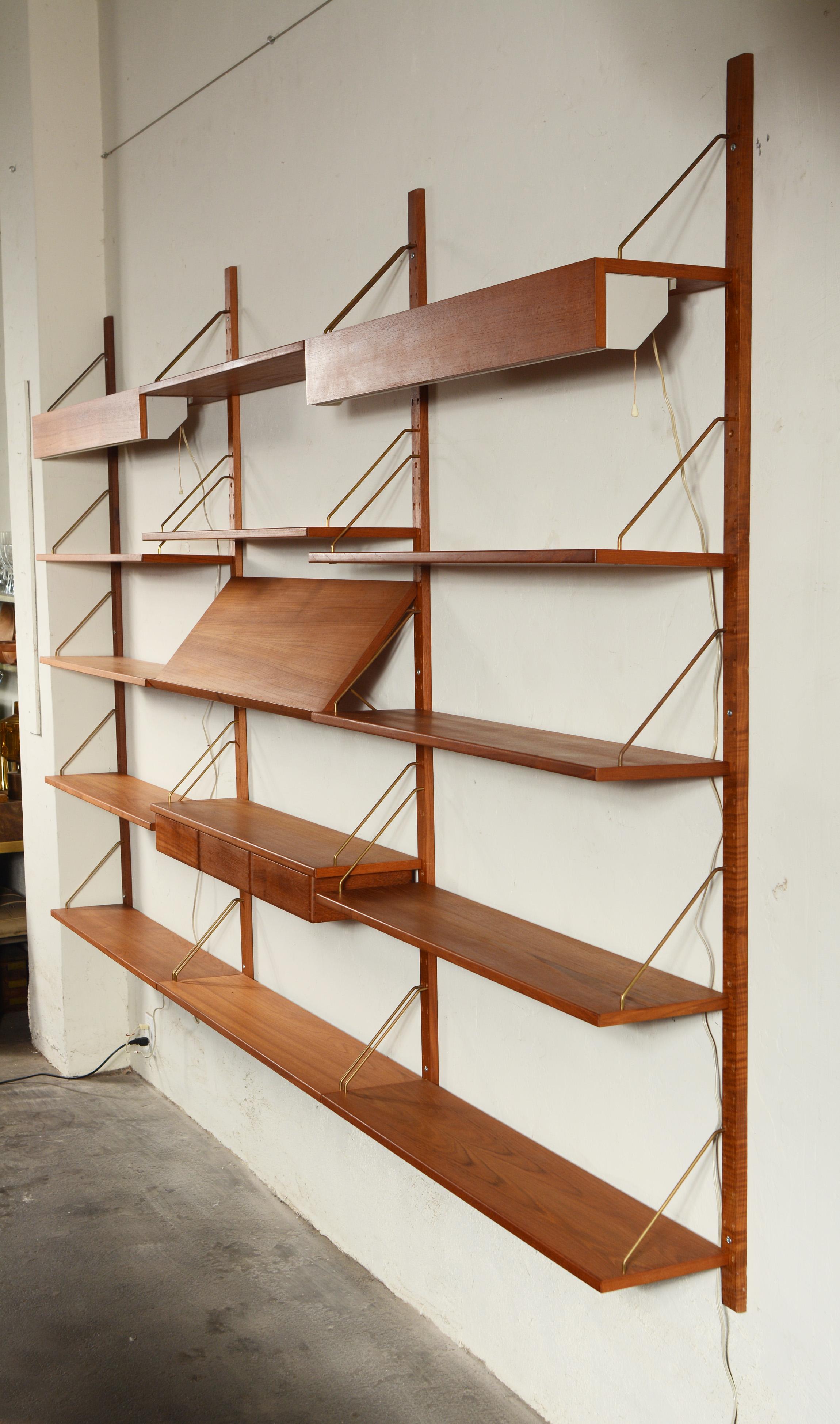 Omnibus wall unit designed by Sven Ellekaer. These were made by Albert Hansen in Denmark and imported to the United States by Raymor. As shown there are two shelves with lights, eleven shelves, one shelf with drawers underneath, one magazine shelf