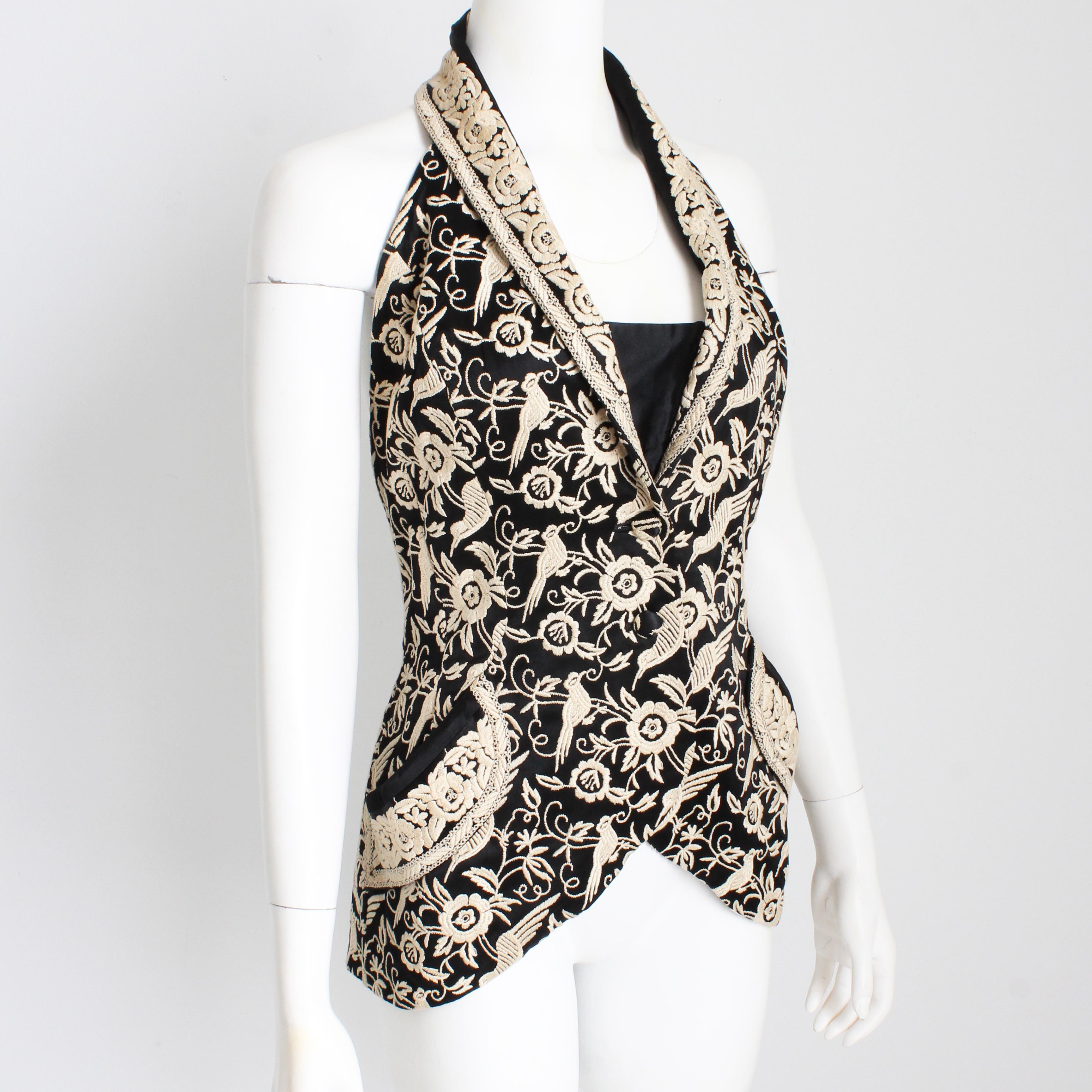 Preowned, vintage Norma Kamali OMO halter top, sold by high end boutique Fred Hayman Beverly Hills and likely made in the early 90s.  Made from black fabric, it features gorgeous cream-colored embroidery of scrolling flowers and birds throughout. 