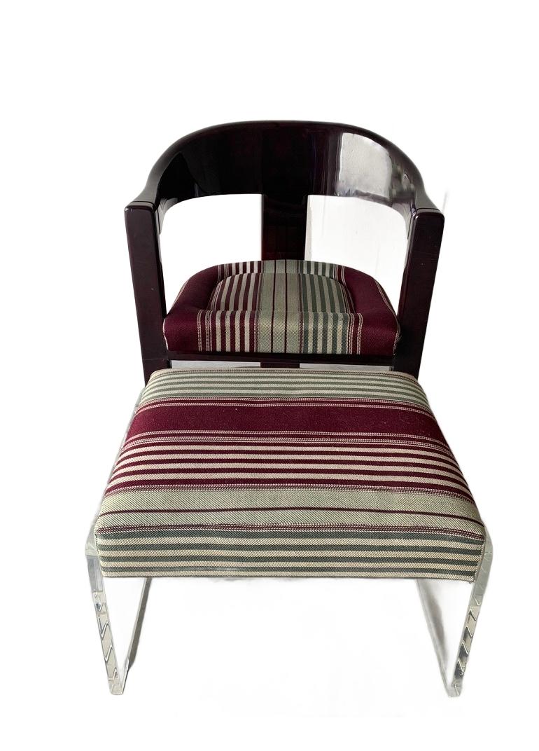 Iconic mid-century Onassis chair with ottoman, attributed to Karl Springer. Seat cushions are upholstered in a purple and olive roman stripe fabric with comfortable foam inserts. 

There are cracks & scratches on the top back portion of the chair