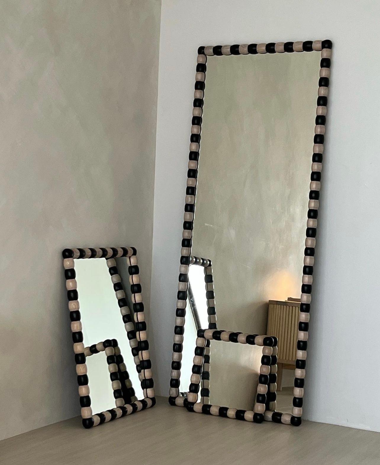 Lo specchio Onde è uno dei pezzi forti dello Studio Wood, noto per la sua audace cornice in legno nero e naturale. Ispirato ai ricordi della designer Faezah Shaharuddin sui dolci del sud-est asiatico della sua infanzia, il motivo bicolore è