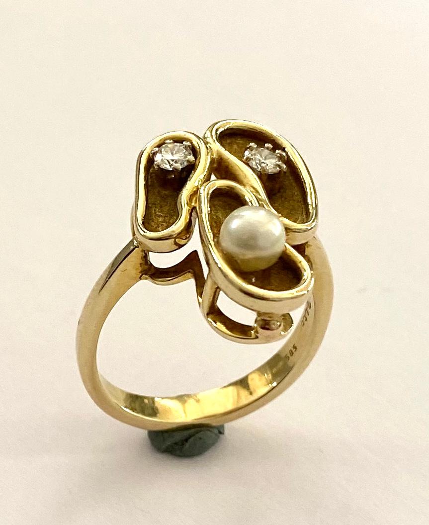 One (1) 14K. Yellow Gold ring, handmade in Germany ca 1960
set with:
2 Two Round Brilliant Cut Natural Diamonds weight: 0.24 ct. SI/Wesselton H.
1 One Natural Cultured Pearl 0.90 ct.  (4.7 mm)
Total weight Ring: 8.78 grams
Size of the ring18.75 ( 59