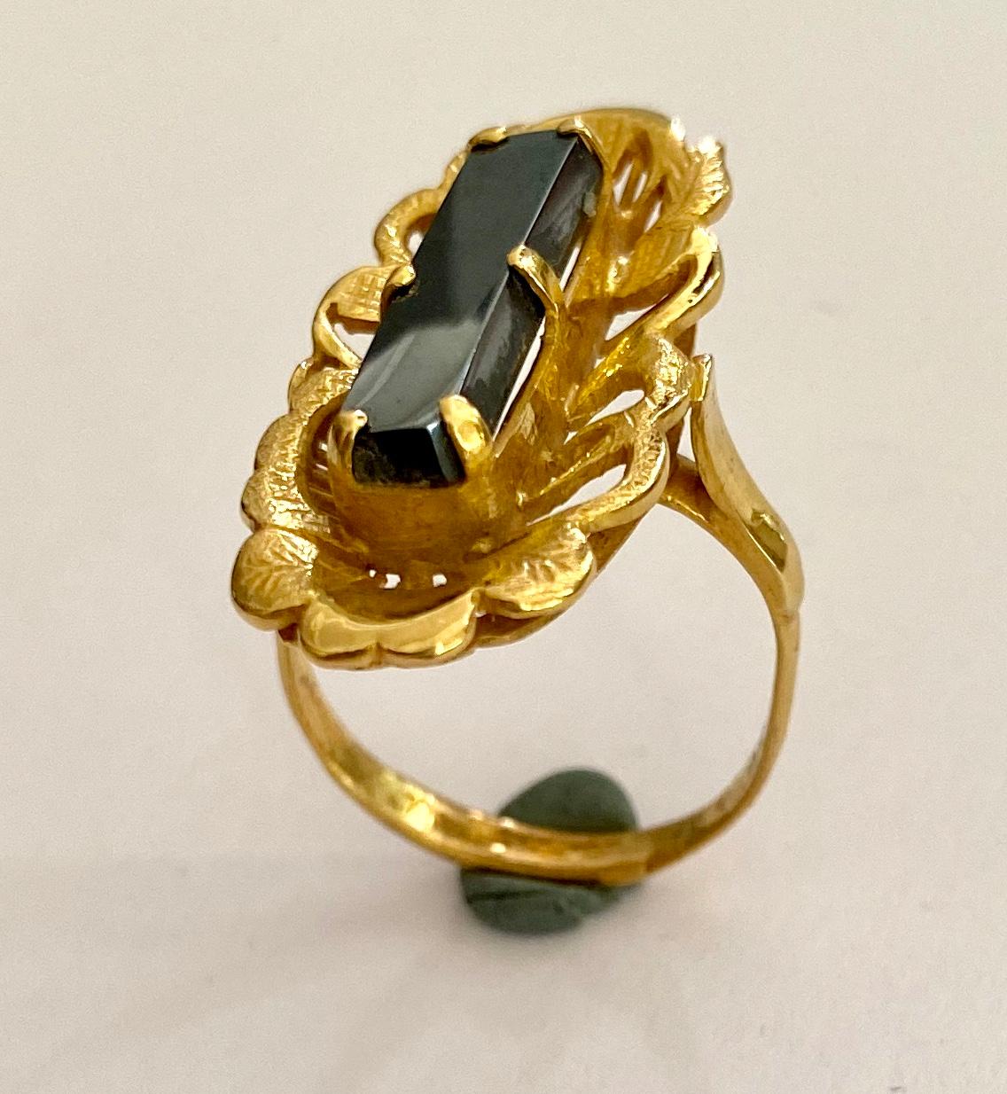 One (1) 20 K. 833/- Yellow Gold Ring in a typicel Indonisia styling, handmade
set with:
One Natural Hematite stone in a rectangle Cabuchon Cut
Messurment: 19.86 x 5.05 x 2.74 mm =  ca.  4.00 ct.
Size :  20 ( 62 )    10  ( We can make this ring on