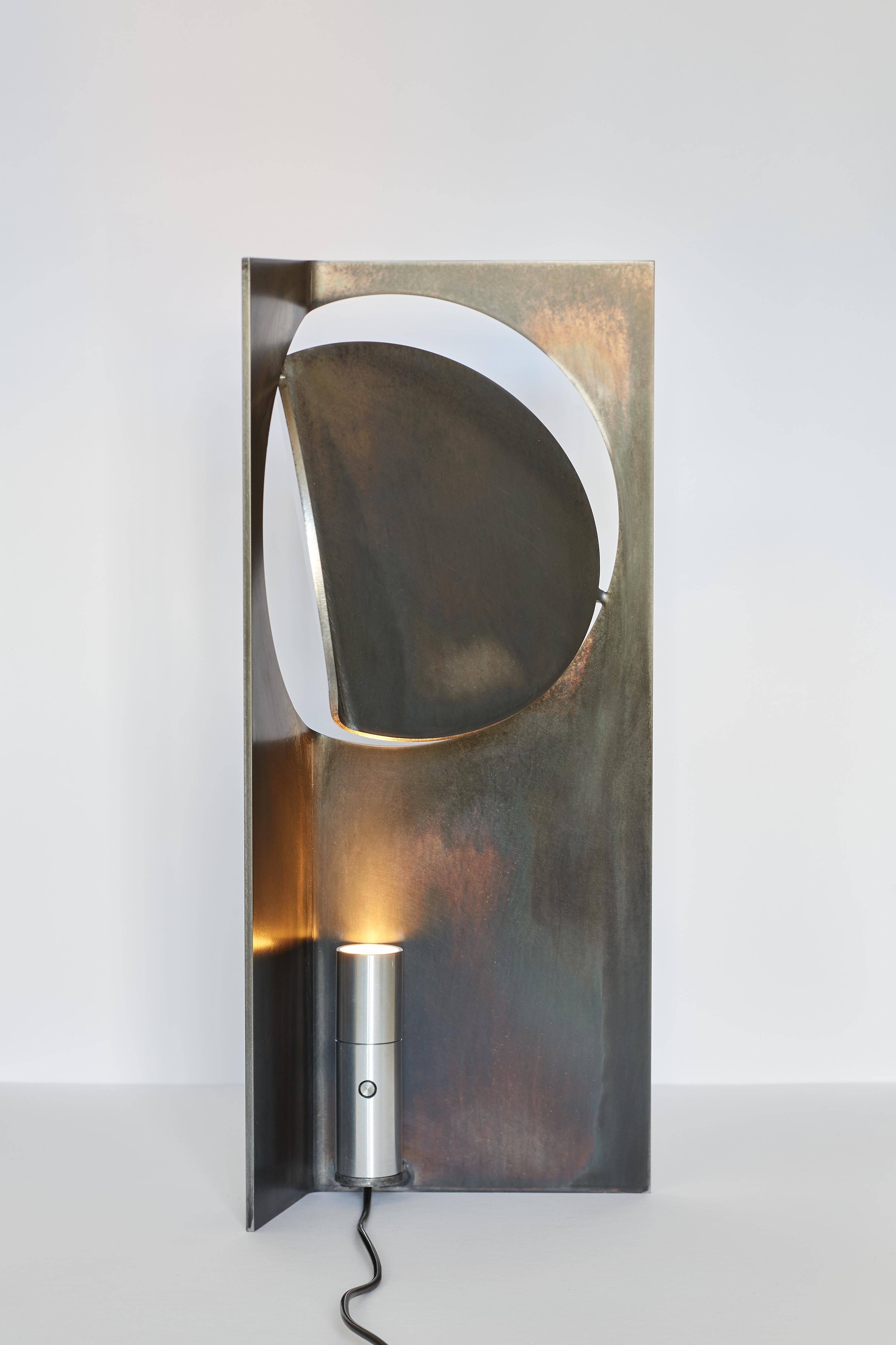 La collection ONE Table Light de Frank Franks est une série de luminaires qui allient une ingénieuse simplicité de forme à une richesse de lumière et de texture matérielle. Dotée d'un design en acier inoxydable brossé à la main, cette lampe de table