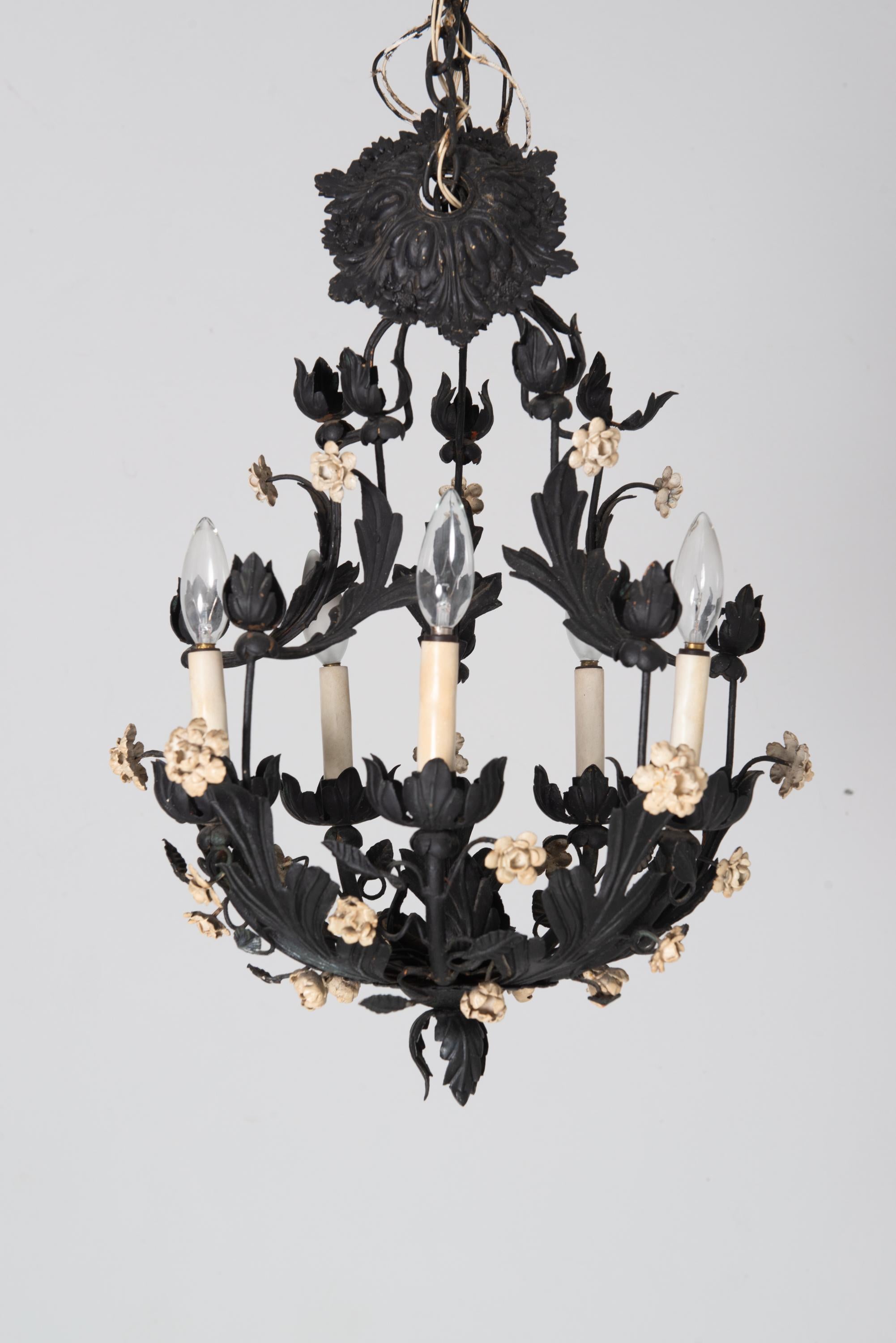 Un lampadario italiano floreale in metallo dipinto di nero con fiori in metallo dipinti di bianco. Ha cinque prese di dimensioni da lampadario e include il baldacchino. 
Sono disponibili due lampadari. Hanno un prezzo individuale.