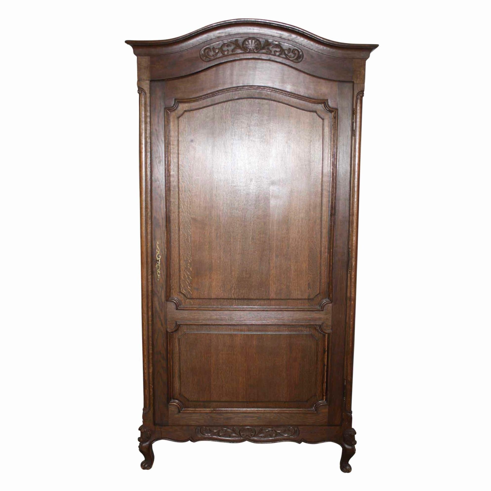 Matched carvings of a shell flanked by scrolling, acanthus leaves adorn the arched bonnet and scalloped apron of this single door armoire. The door opens to three adjustable shelves. The sides are comprised of four raised panels. Cabriole front legs