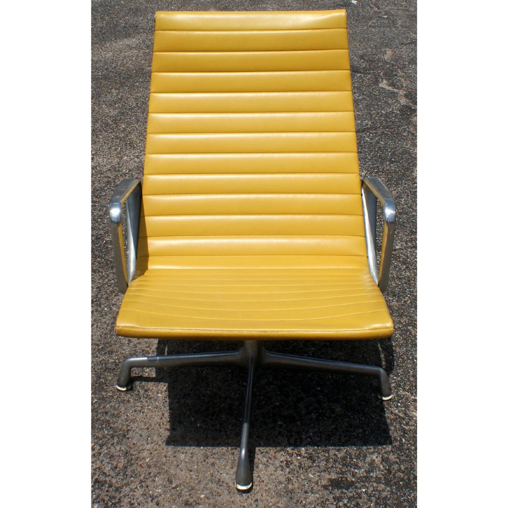 One Mid-Century Modern lounge chair designed by Charles and Ray Eames and made by Herman Miller. Extruded aluminum frame on four-star swivel base with yellow vinyl upholstery.