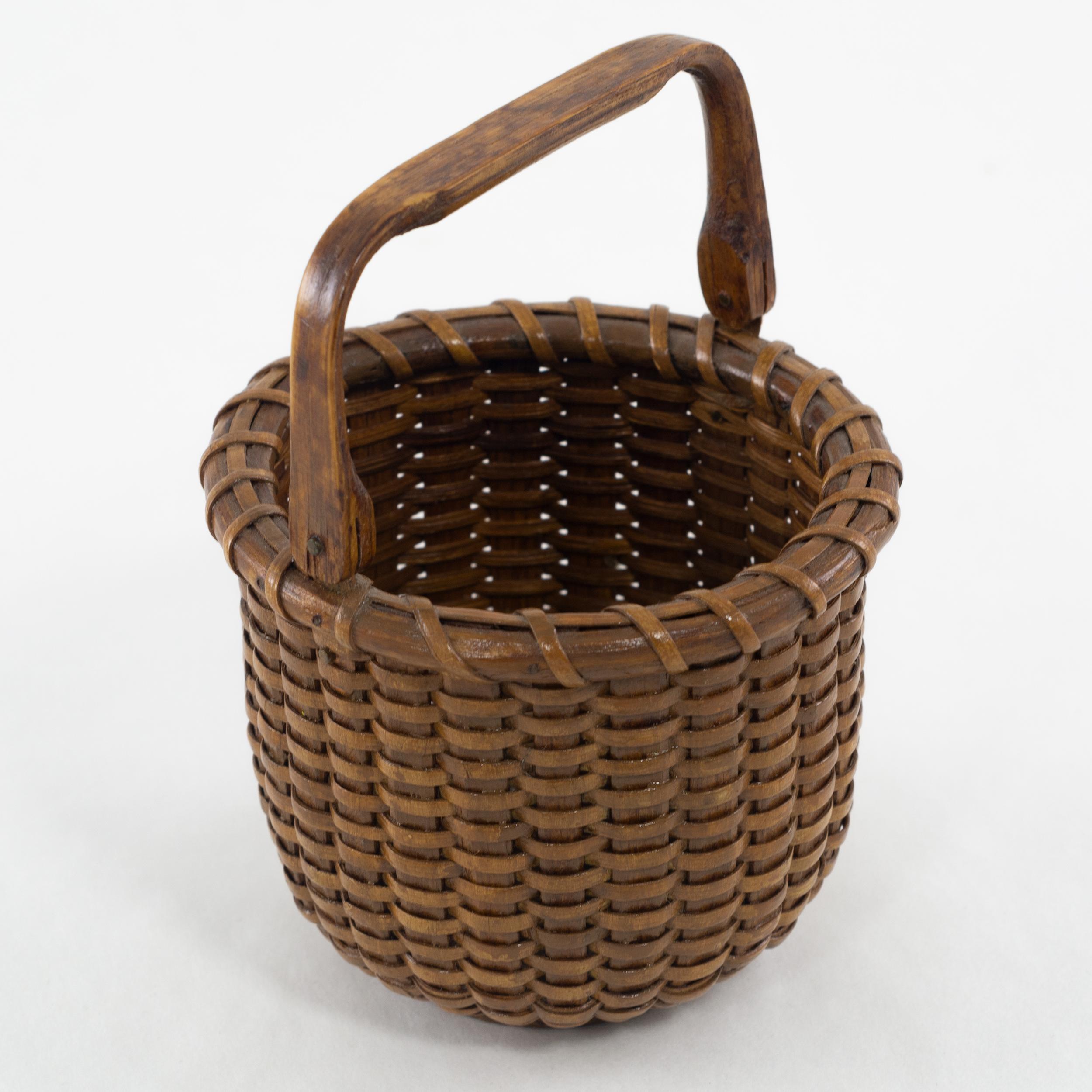 One egg Nantucket lightship basket in great condition with a rich honey patina. Constructed with Oak staves and swing handle, brass ears.
Unknown maker, circa 1940.