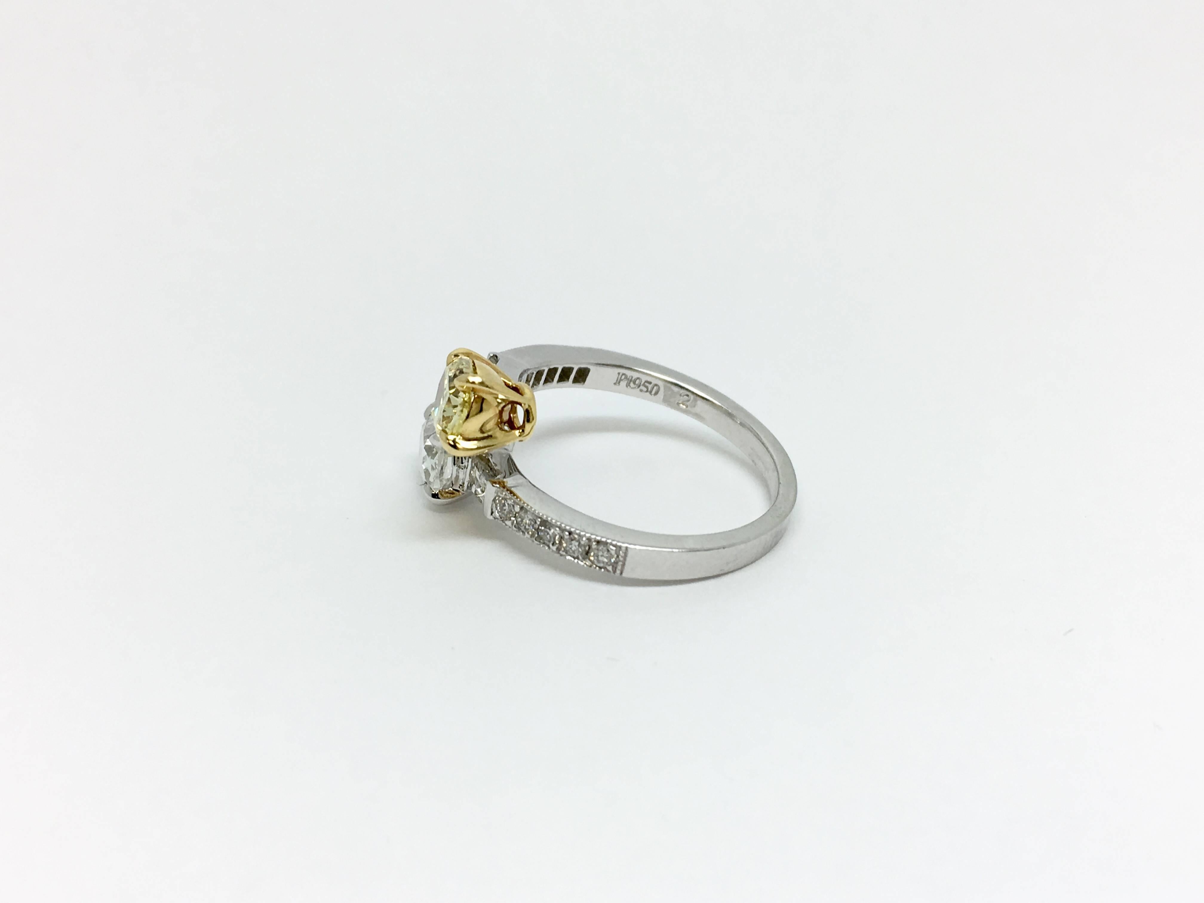 One fancy platinum swirl design diamond ring. The yellow oval diamond is .75 carat with VS clarity and the white oval diamond is .70 carat with an SI clarity and H colour. This ring is beautifully accented with round brilliants and baguettes on each