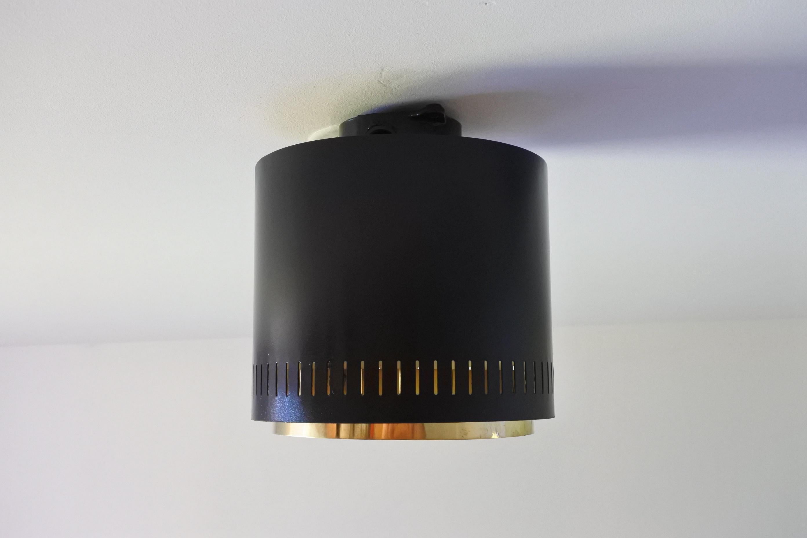 One AE 97/20 flush mount ceiling light. 
Designed and manufactured by Itsu Oy in Finland in the 1960s. 
Black and white lacquered metal and solid brass. 
The light takes one E27 bulb.
Manufacturer's stamp.

Outstanding ceiling