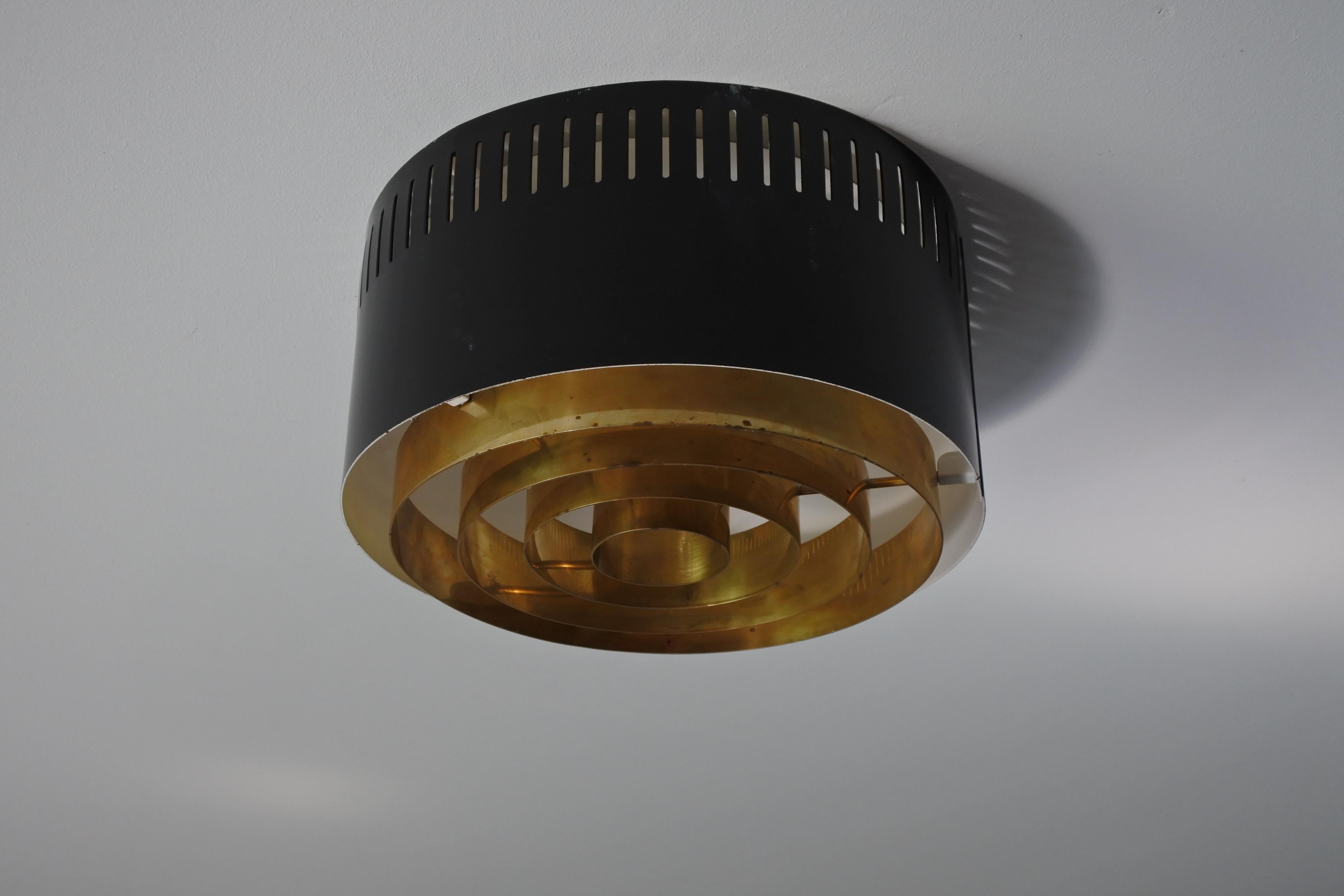 One flush mount ceiling light. 
Designed and manufactured in Finland in the 1960s. 
Black and white lacquered metal and solid brass. 
The light takes two E27 bulb.

Outstanding ceiling lamp.

Original electrical system. To be safe, the lamp