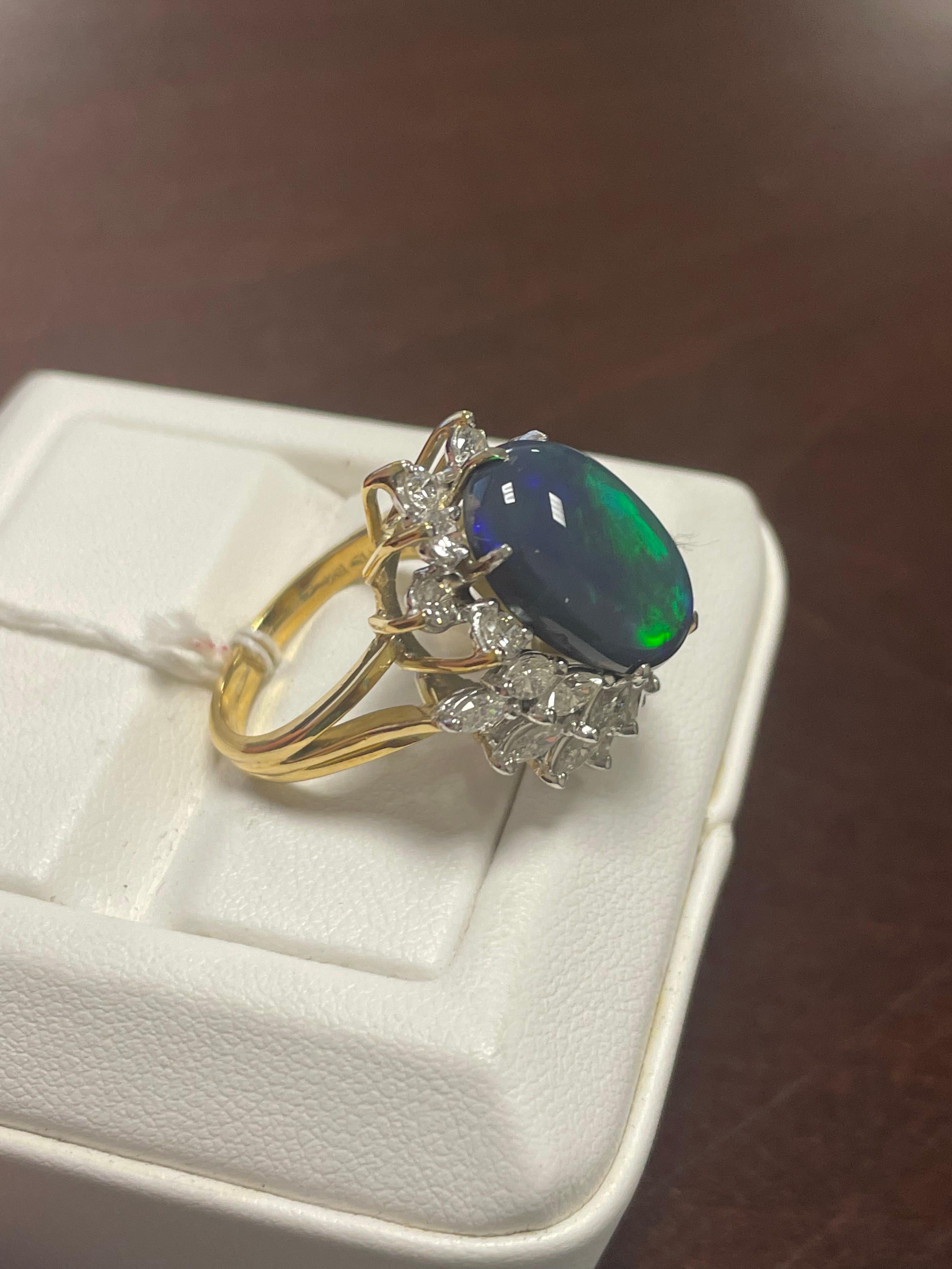 One Lady's black opal and diamond rings with platinum and 18k yellow gold.  This piece is vivid, broad flashy, and extremely bright with brightness of fire.  Fire pattern is seen through saturation scale.  Measurements include 16.8 x 11.5 mm, with