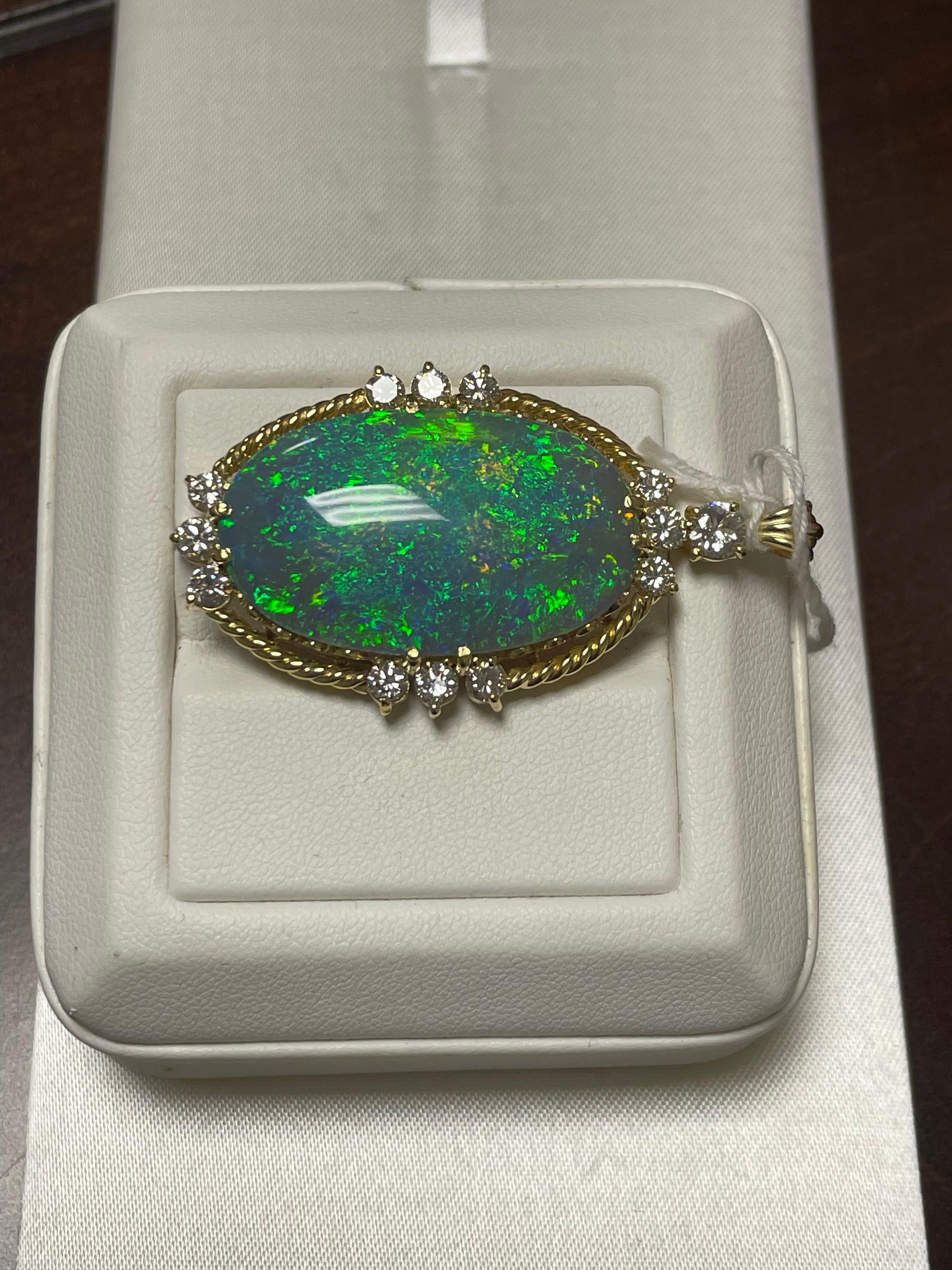 One Lady's semi-black opal with blue/green fire color.  Vivid saturation scaled with pinfire pattern.  Measurements of opal are 32.5 x 19.5 and weight consists of 25.0 carats. Diamonds are 12 round brilliant-cut measuring 4.5-3.0 mm.  Weight is 1.35