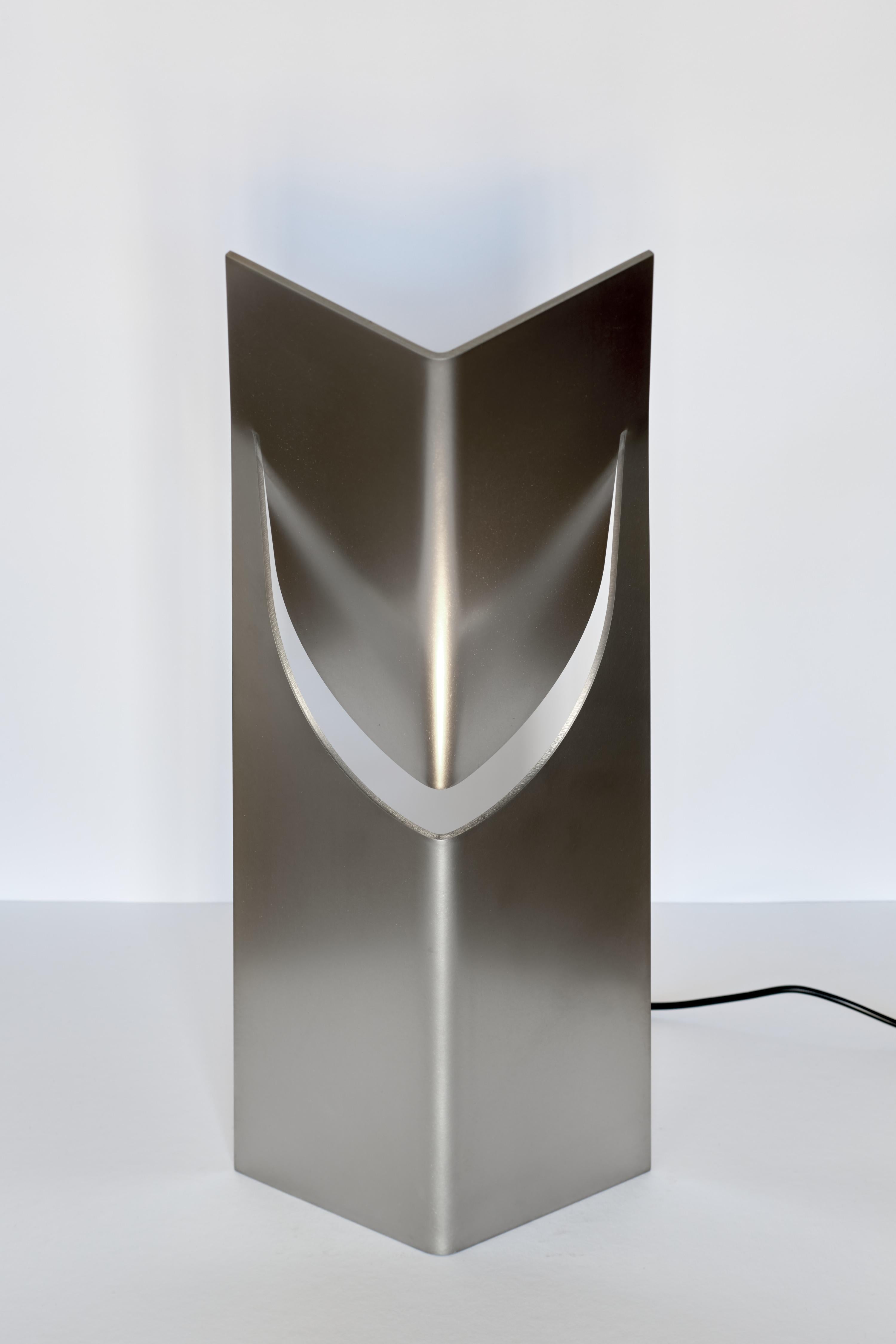 The ONE Table Light collection by Frank Penders for Form Editions is a series of lights that combine an ingenious simplicity of form with a richness of light and material texture. Featuring a hand brushed stainless steel design, this table light is
