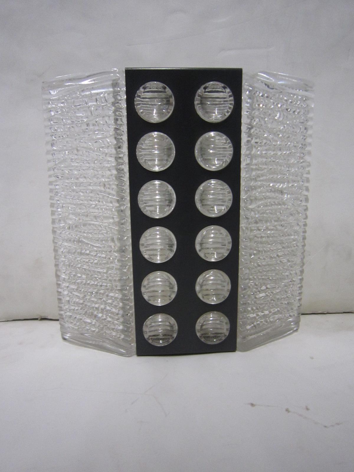 A Modernist Kaiser Leuchten wall sconce, textured glass with blackened metal overlay in circular pattern.
Wired for U.S. specs.
This wall light can be used in any room setting, ie: bath, entry, foyer, bedroom, den, office, child's room,  and with