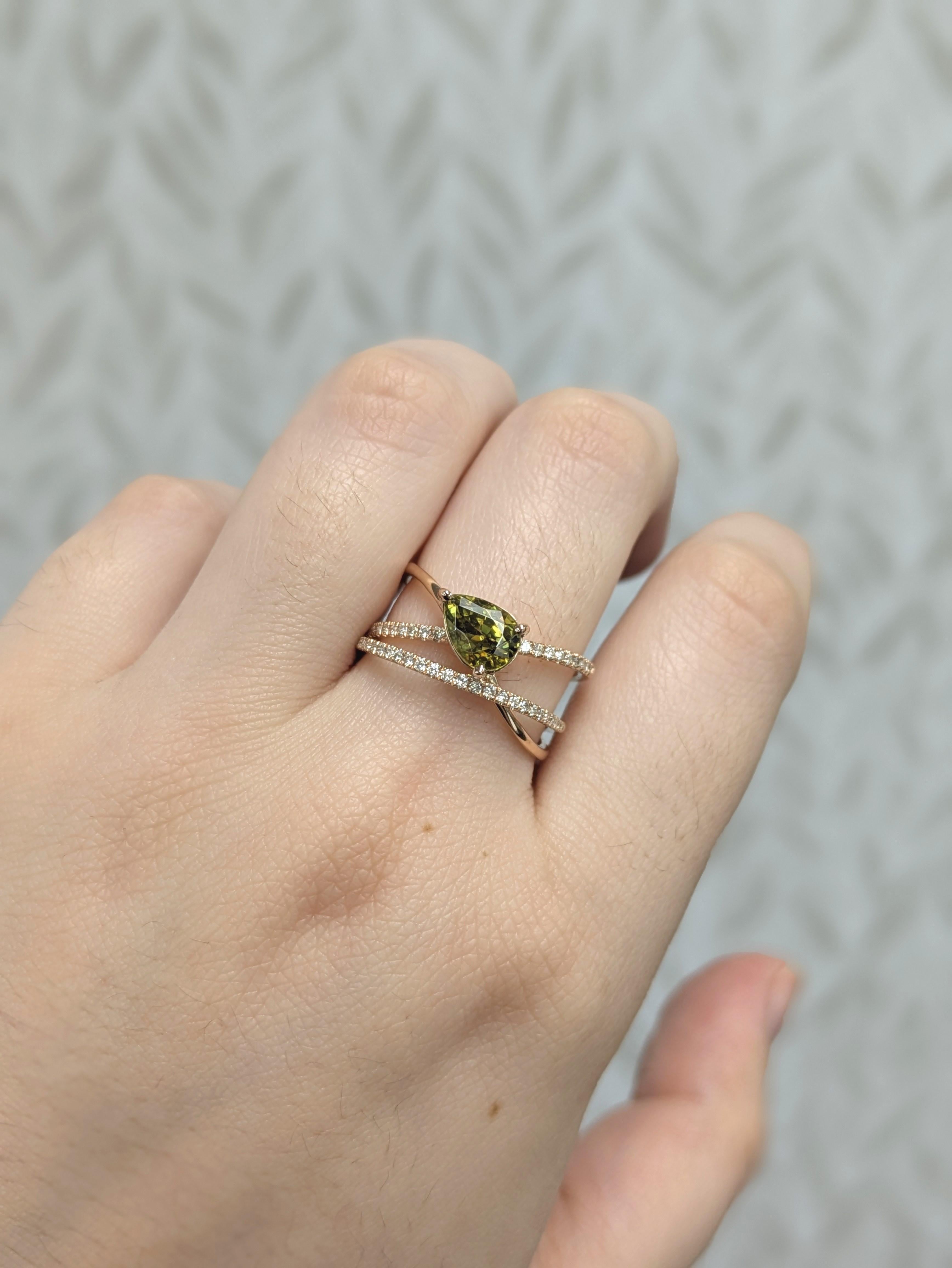 Dieser bezaubernde Ring enthält einen 1,65 ct großen birnenförmigen Sphene (8x6 mm), der für seine feurige Brillanz und sein lebhaftes Farbspiel bekannt ist. Umgeben von 46 natürlichen Diamanten (0,23cttw) und gefasst in 14-karätigem Gold (3,08g),