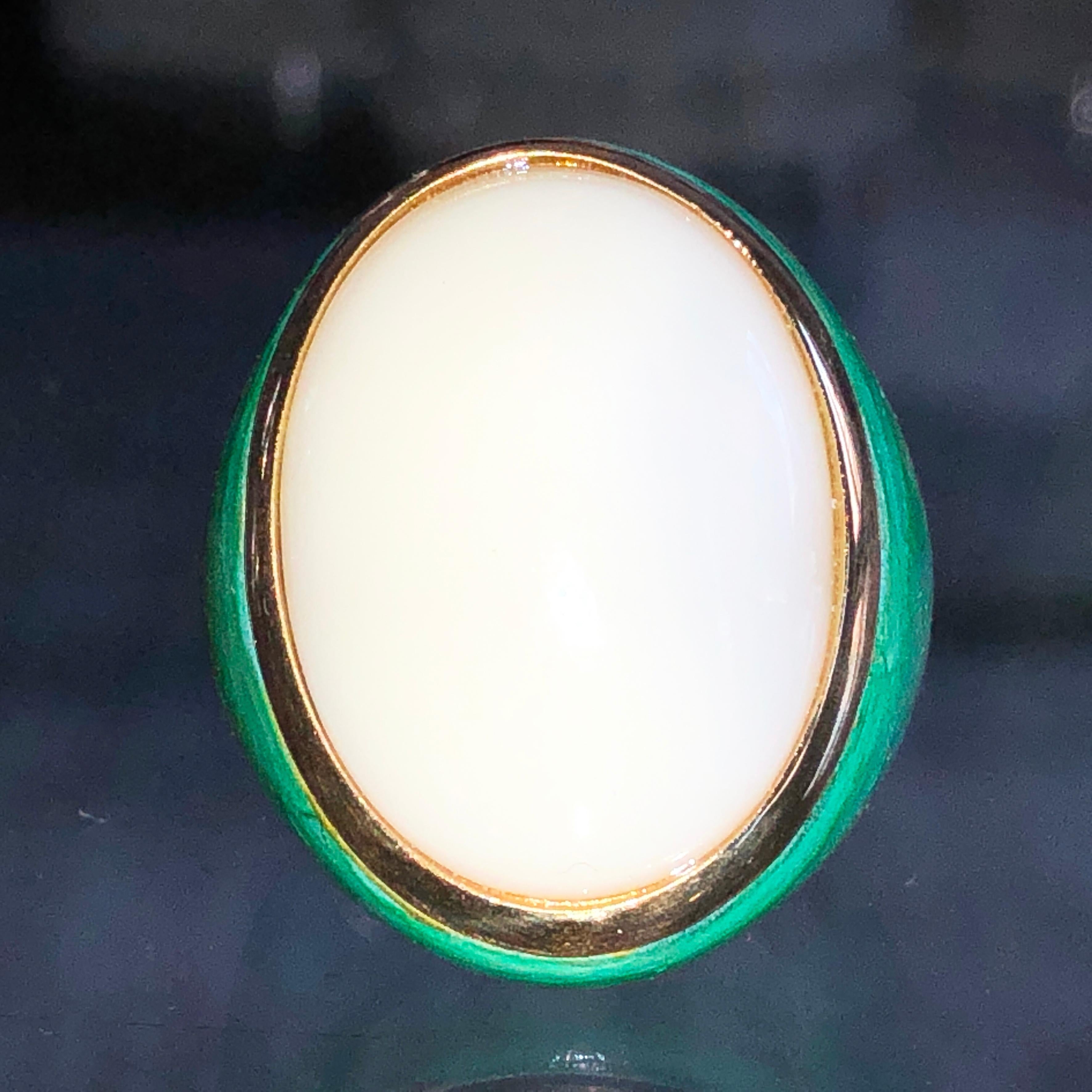 Bague de cocktail contemporaine unique en son genre, ornée d'un cabochon d'opale blanche naturelle de 20 carats (0,911x0,666in) dans une monture en or jaune 18 carats turquoise-vert oxydée à la main.
Le changement de couleur du cabochon de l'opale