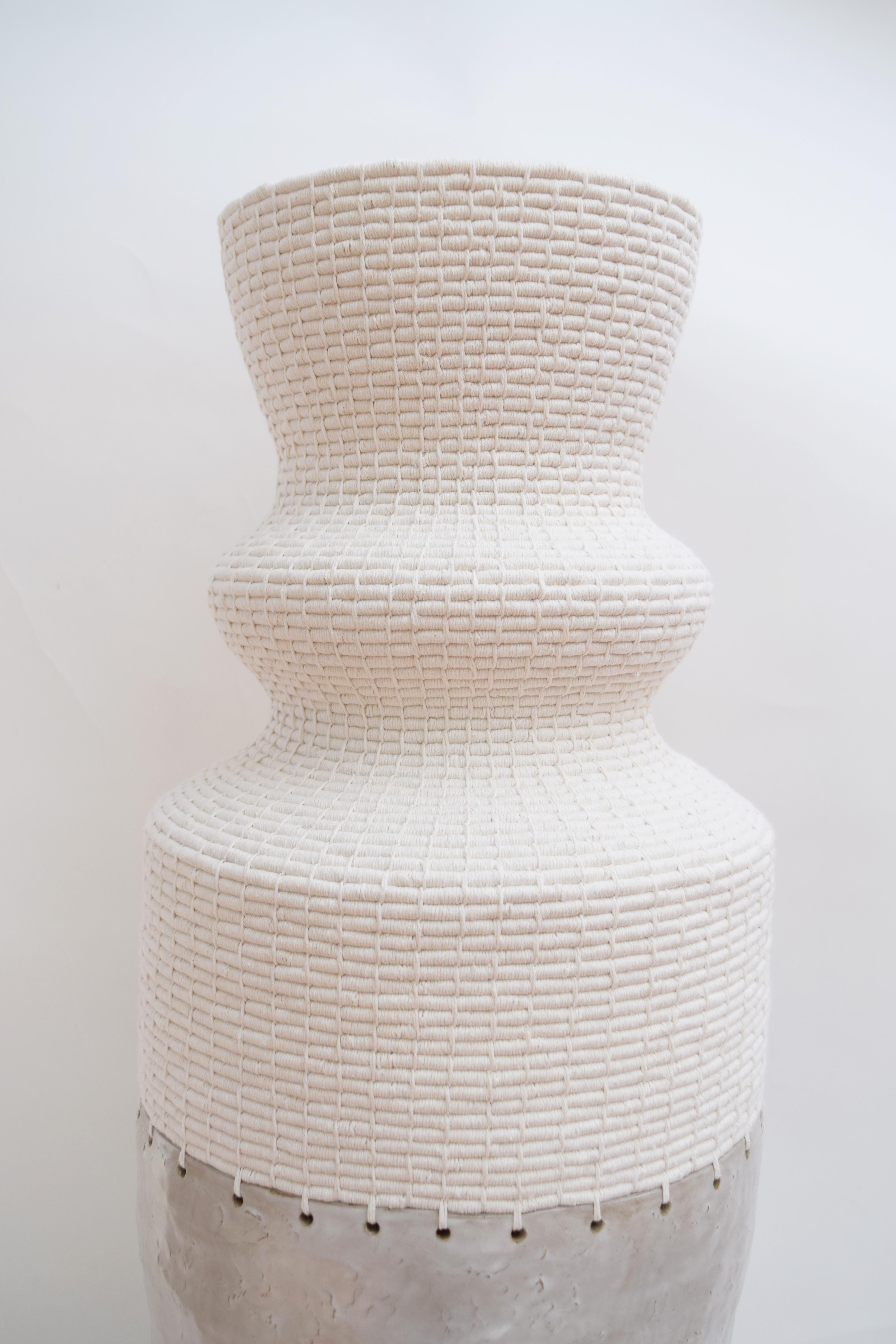 One of a kind Vessel #824 by Karen Gayle Tinney

Hand formed stoneware base with satin white glaze. The top part is woven in white cotton.

37.5”H x 12”W

One of a kind collections are released periodically throughout the year. Each piece is