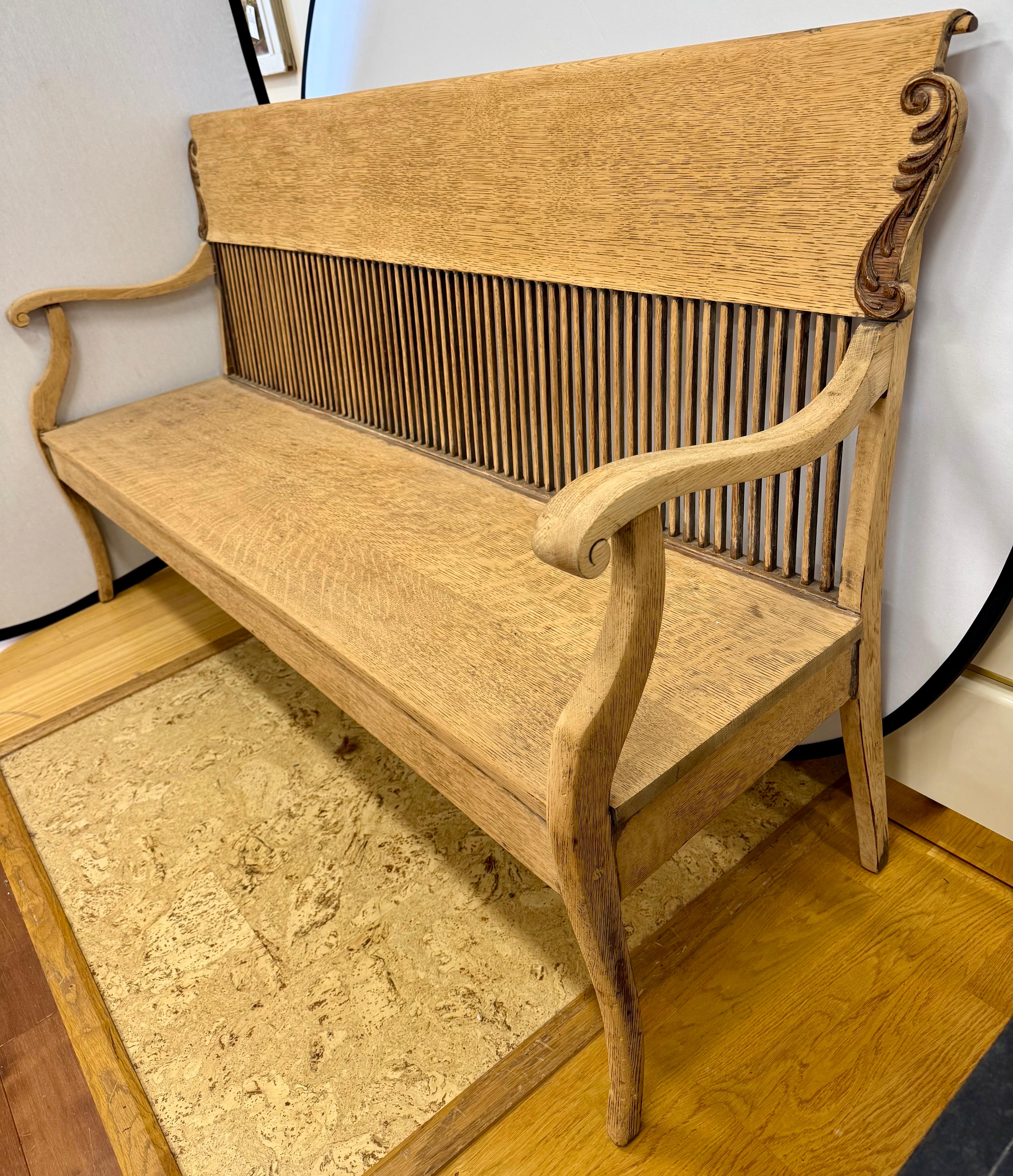 Außergewöhnliches antikes Spindelsofa aus Massivholz.  Diese Bank zeichnet sich durch anmutig geschwungene Armlehnen, fein geschnitzte Verzierungen an den Ecken und eine charakteristische Spindelrückenlehne aus, die sowohl visuelles Interesse als