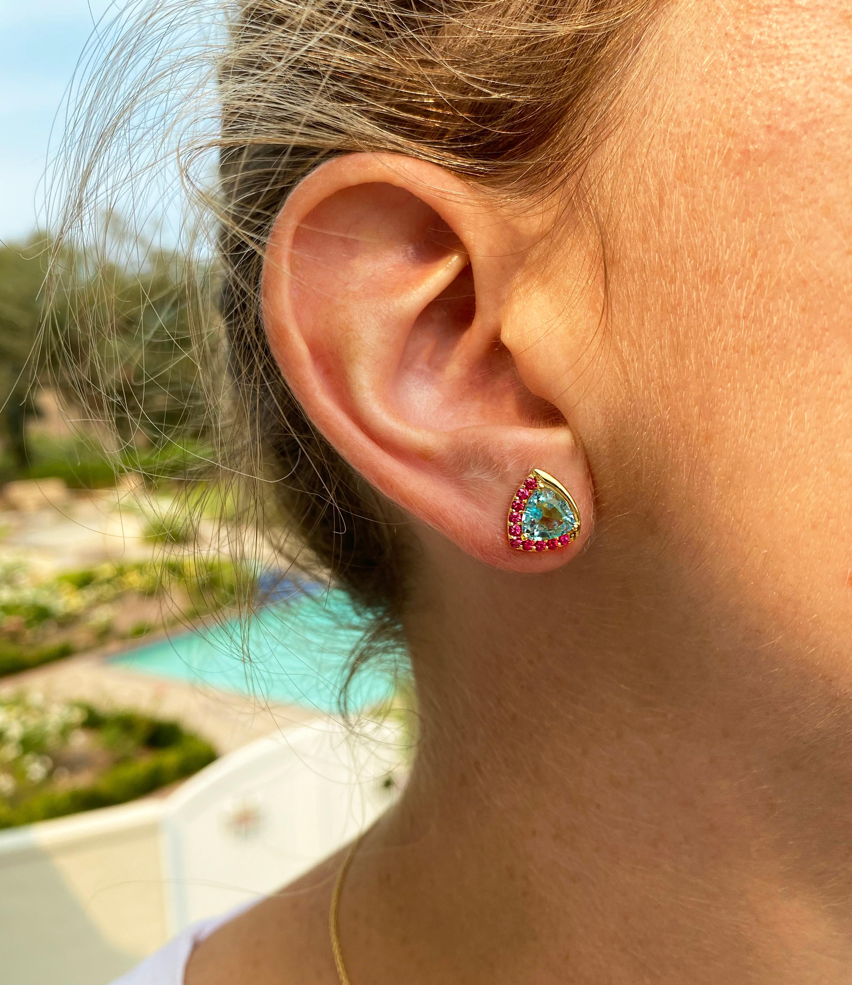 Deux aigues-marines de taille trillion totalisant 2,21 carats sont entourées d'une vague d'or d'un côté et de spinelles Jedi vibrants totalisant 0,40 carat de l'autre côté pour créer une paire de boucles d'oreilles unique. Ce design a été inspiré