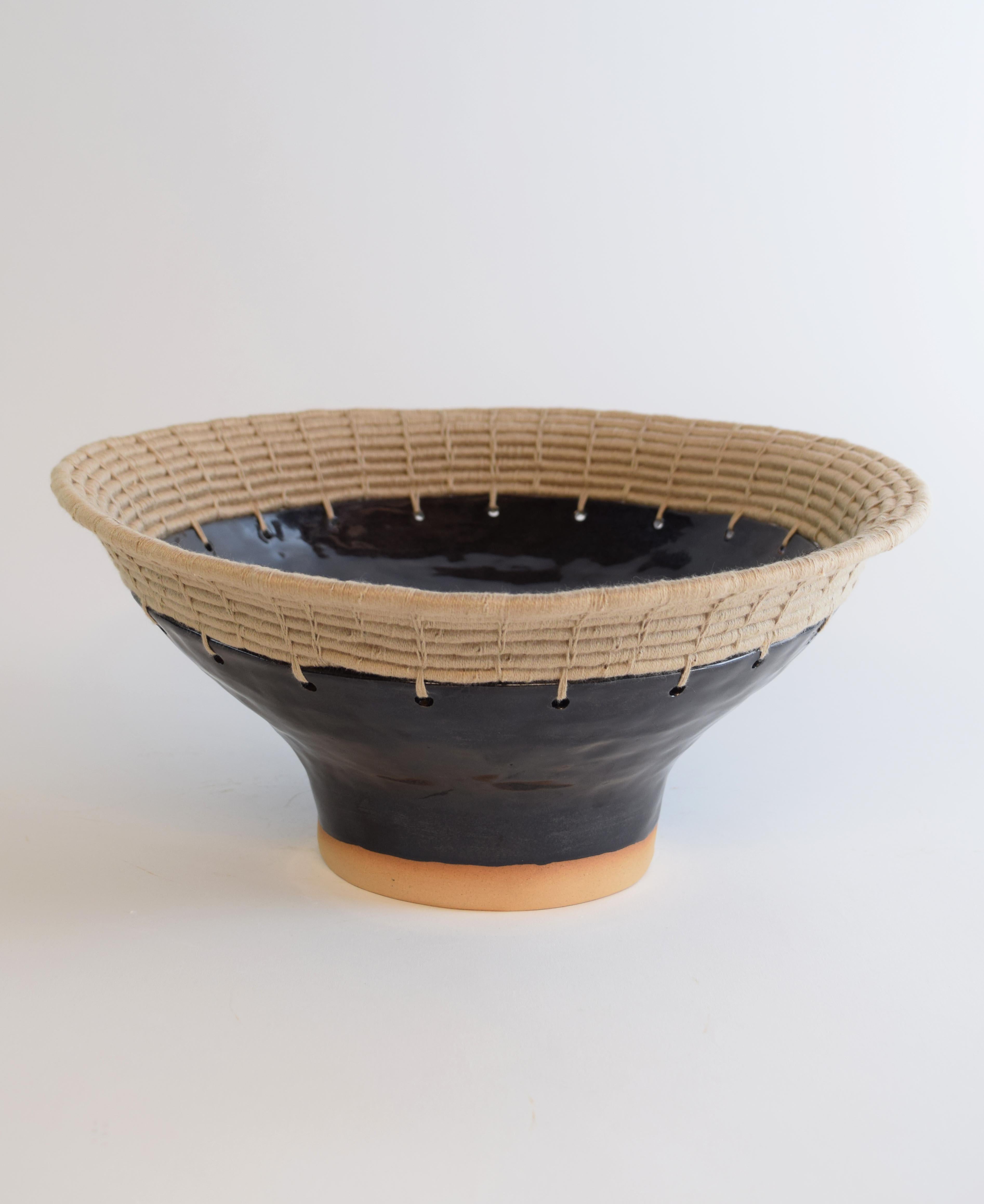 Decorative bowl #778 by Karen Gayle Tinney

Hand formed stoneware bowl with black glaze. The bowl has an asymmetrical shape and will look different from each side. Woven tan cotton edge detail. For decorative use only.

Measures: 13”W x
