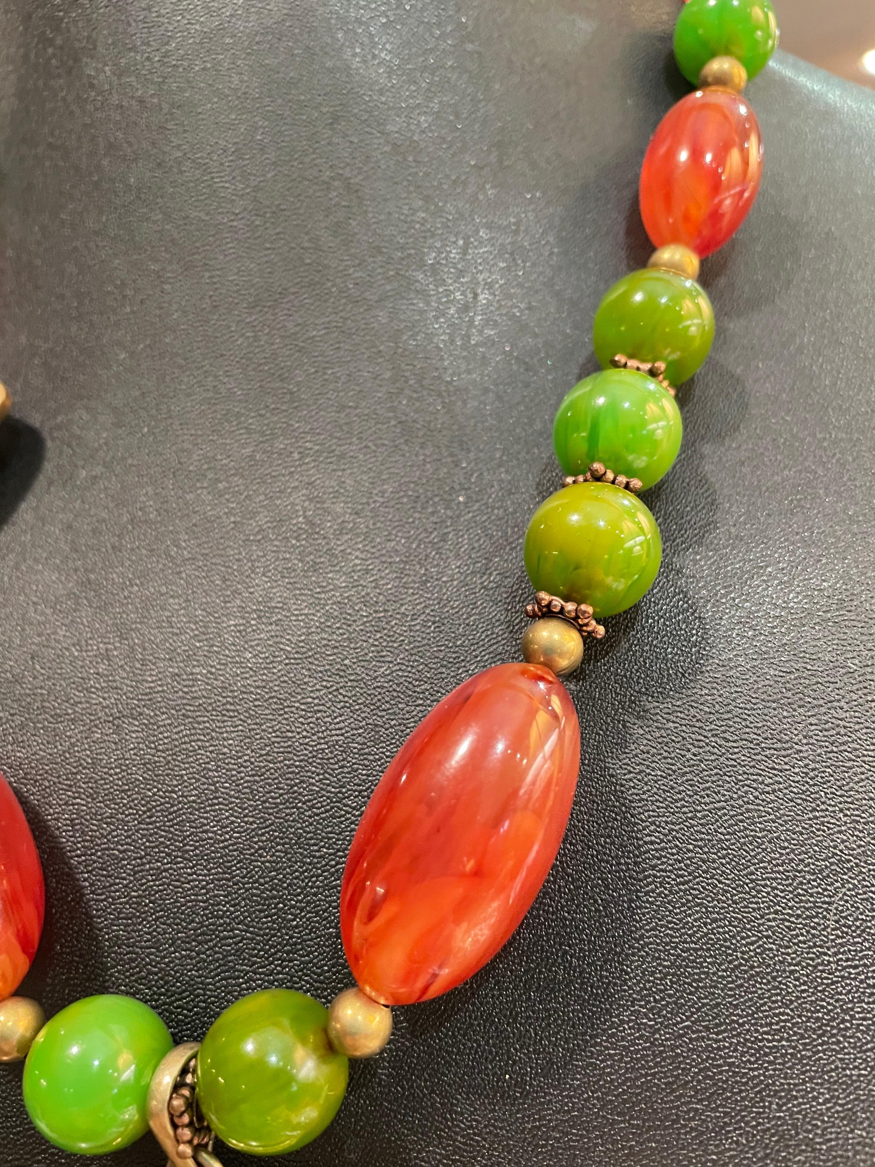 Lorraine’s Bijoux offers a one of a kind, handmade, statement necklace with an antique, carved, Chinese, carnelian pendant.
Vintage Bakelite beads make up the strand from which it hangs..Small brass spacer beads and Tibetan brass bead enhance the
