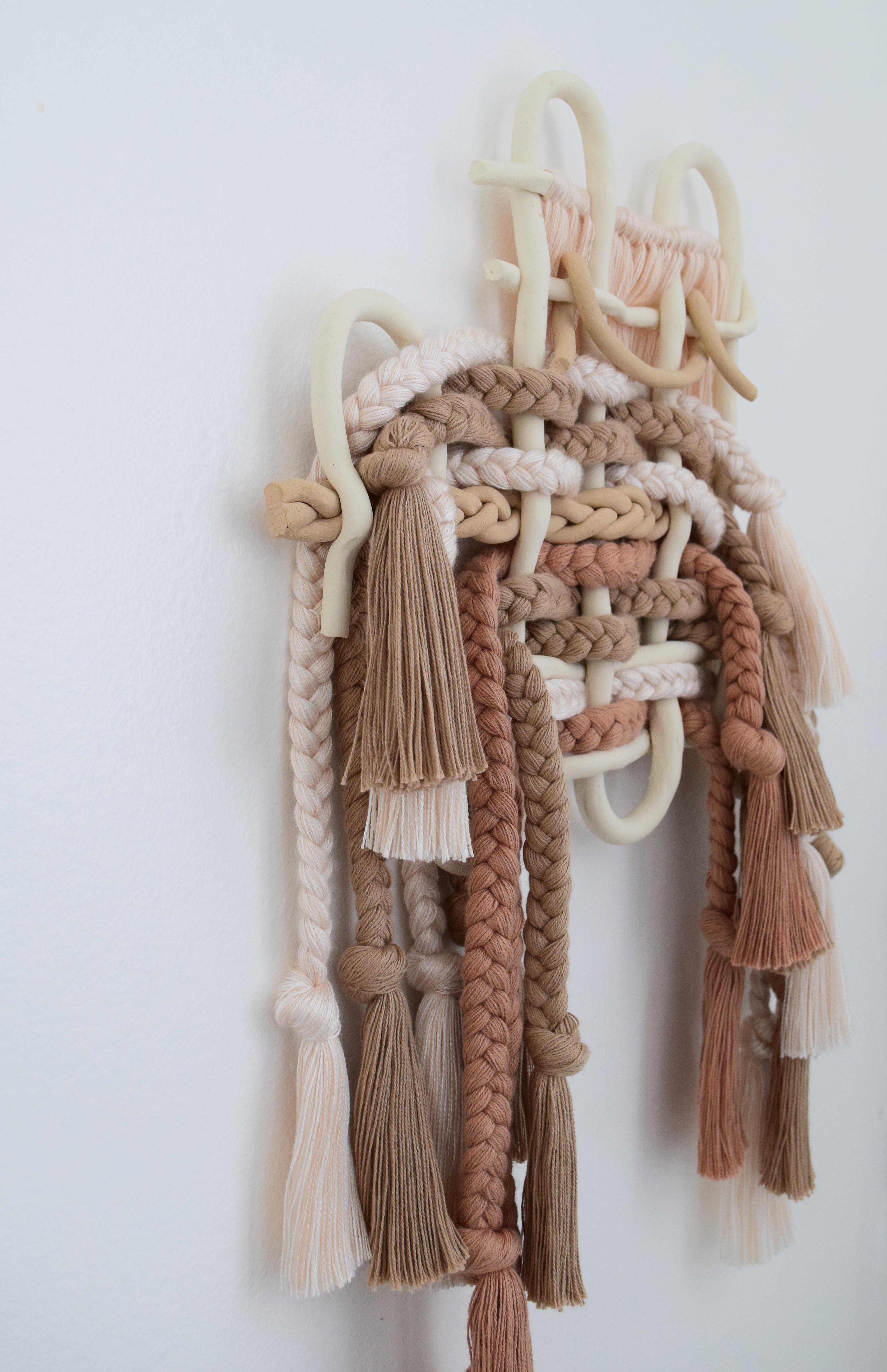 One of a Kind Wall Sculpture #627 By Karen Gayle Tinney

One of a Kind wall sculpture in mixed materials of ceramic and braided cotton/tencel fibers. A woven ceramic panel is intertwined with braids of cotton and tencel in warm neutral colors. The