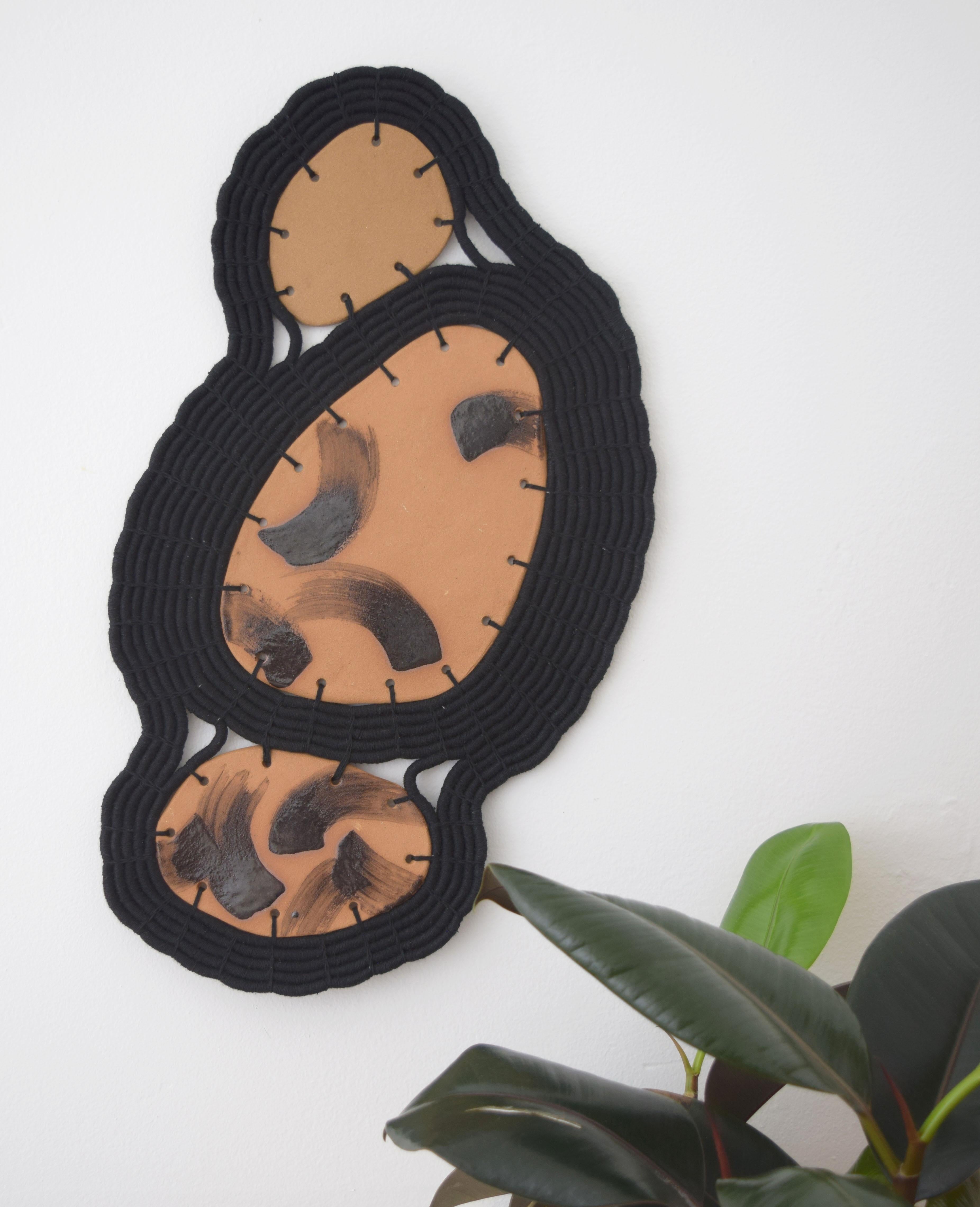 One of a kind wall sculpture #646 by Karen Gayle Tinney

One of a kind wall sculpture in ceramic and woven cotton. Handmade ceramic shapes are left unglazed except for hand painted brushstroke artwork in black. The ceramic pieces are linked