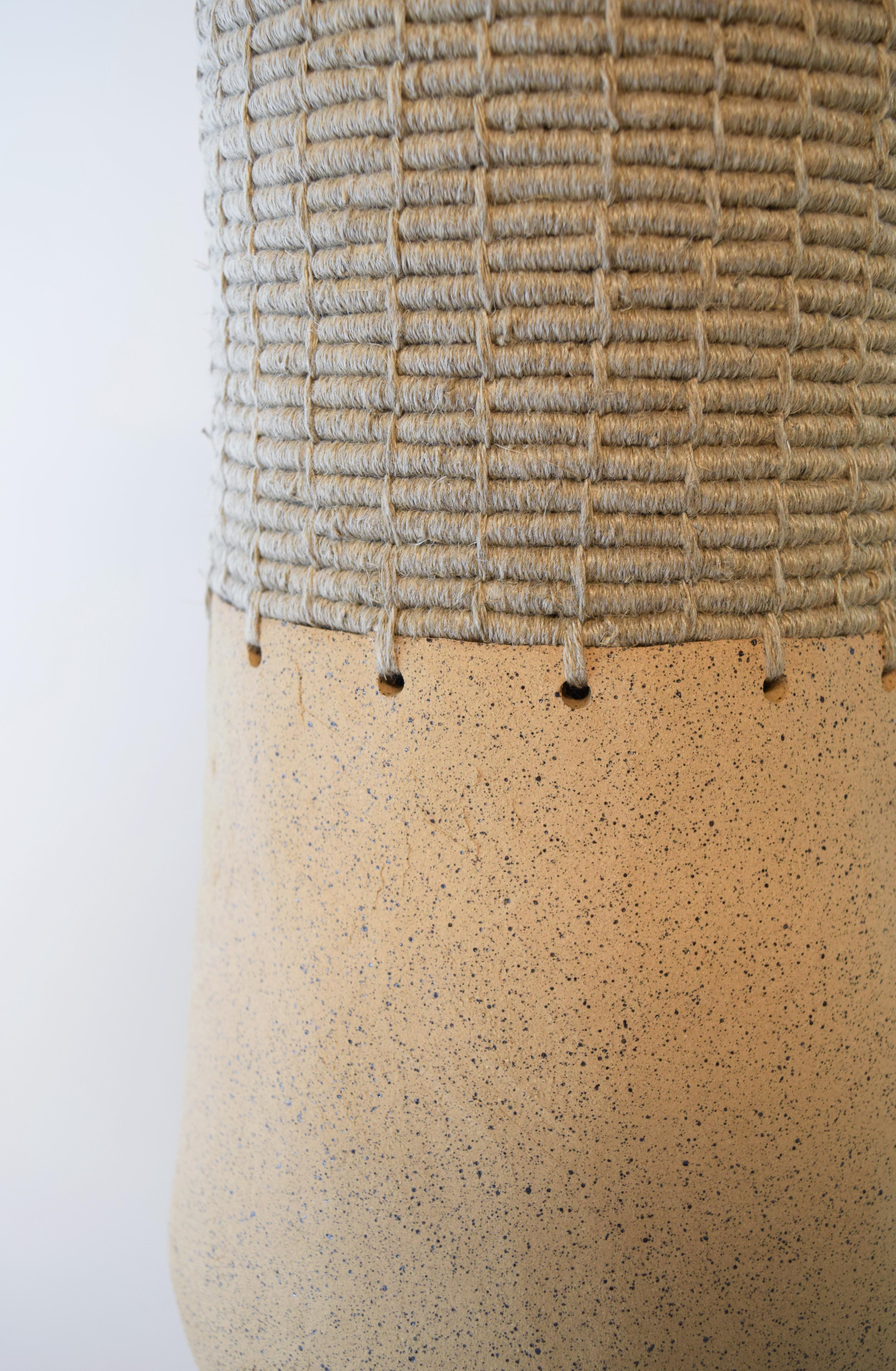 One of a kind Vessel #763 by Karen Gayle Tinney

Hand formed stoneware base with unglazed speckled beige clay. The top part is woven in natural linen.

17.25”H x 7”W

One of a kind collections with a limited number of pieces are released