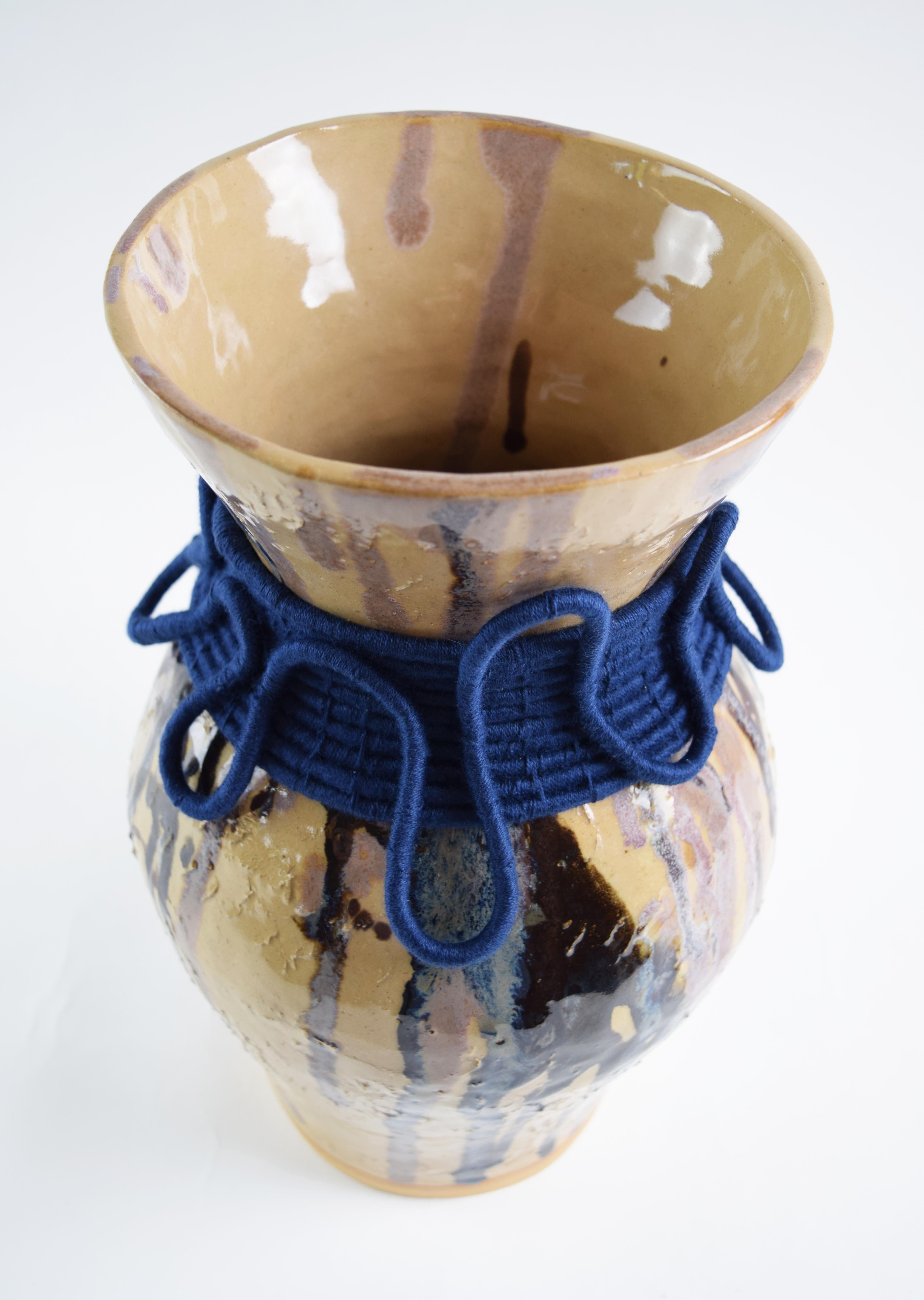 Vaso in gres formato a mano con smalto trasparente e motivi a goccia nei toni del marrone, nero, blu e rosa. Dettagli in cotone navy intrecciato all'esterno. Il vaso è a tenuta stagna.

13,5