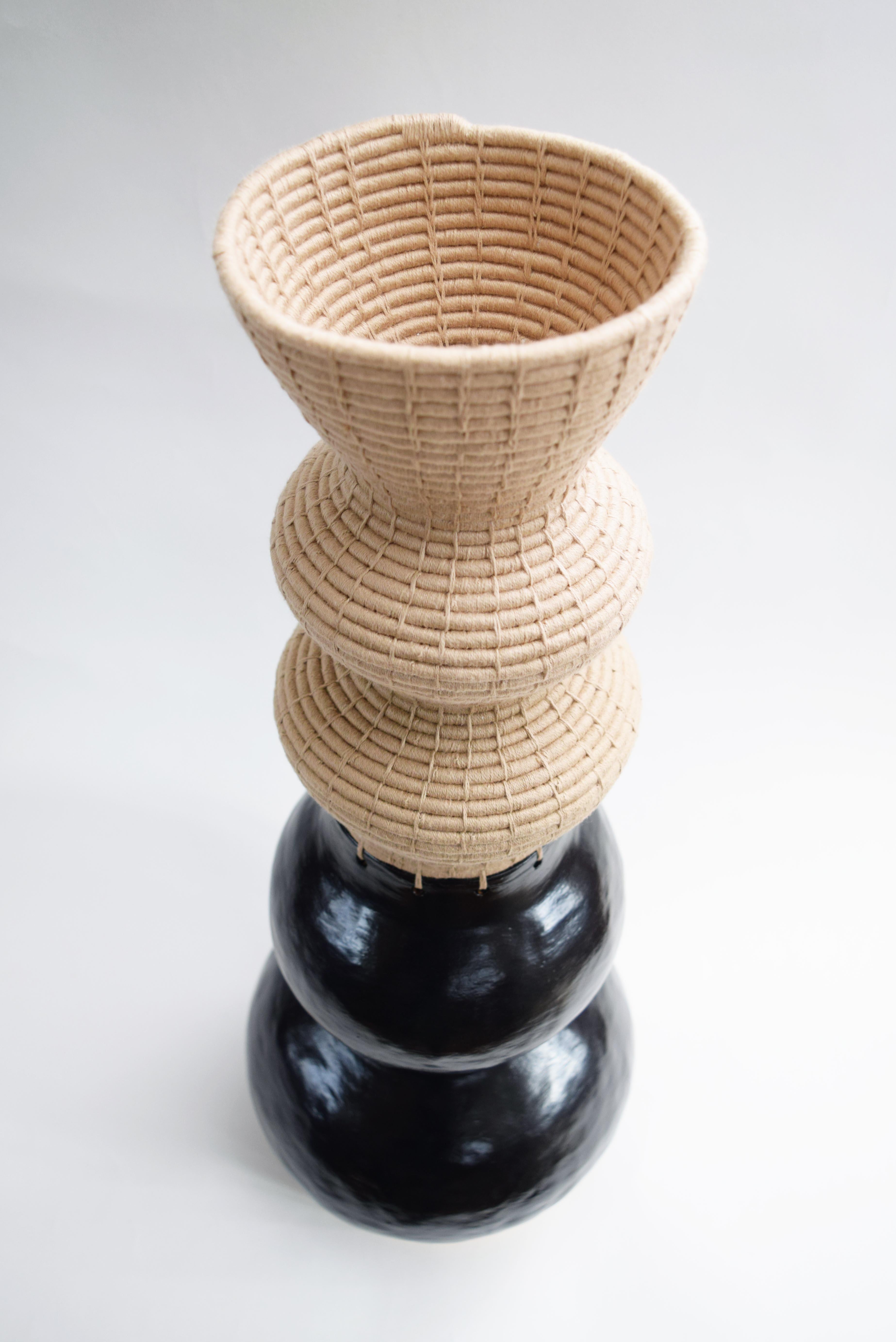 One of a kind Vessel #822 by Karen Gayle Tinney

Hand formed stoneware base with satin black glaze. The top part is woven in tan cotton.

24”H x 8”W

One of a kind collections are released periodically throughout the year. Each piece is meticulously