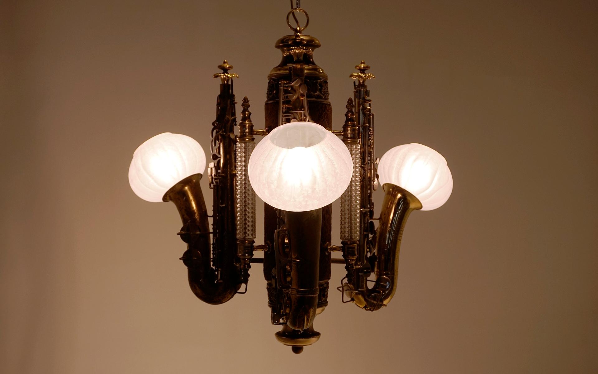 One of a kind super cool custom chandelier made of three brass saxophones and german glass columns and shades. Rich patina to the brass elements. No chips or cracks in any of the glass. Ready to use.