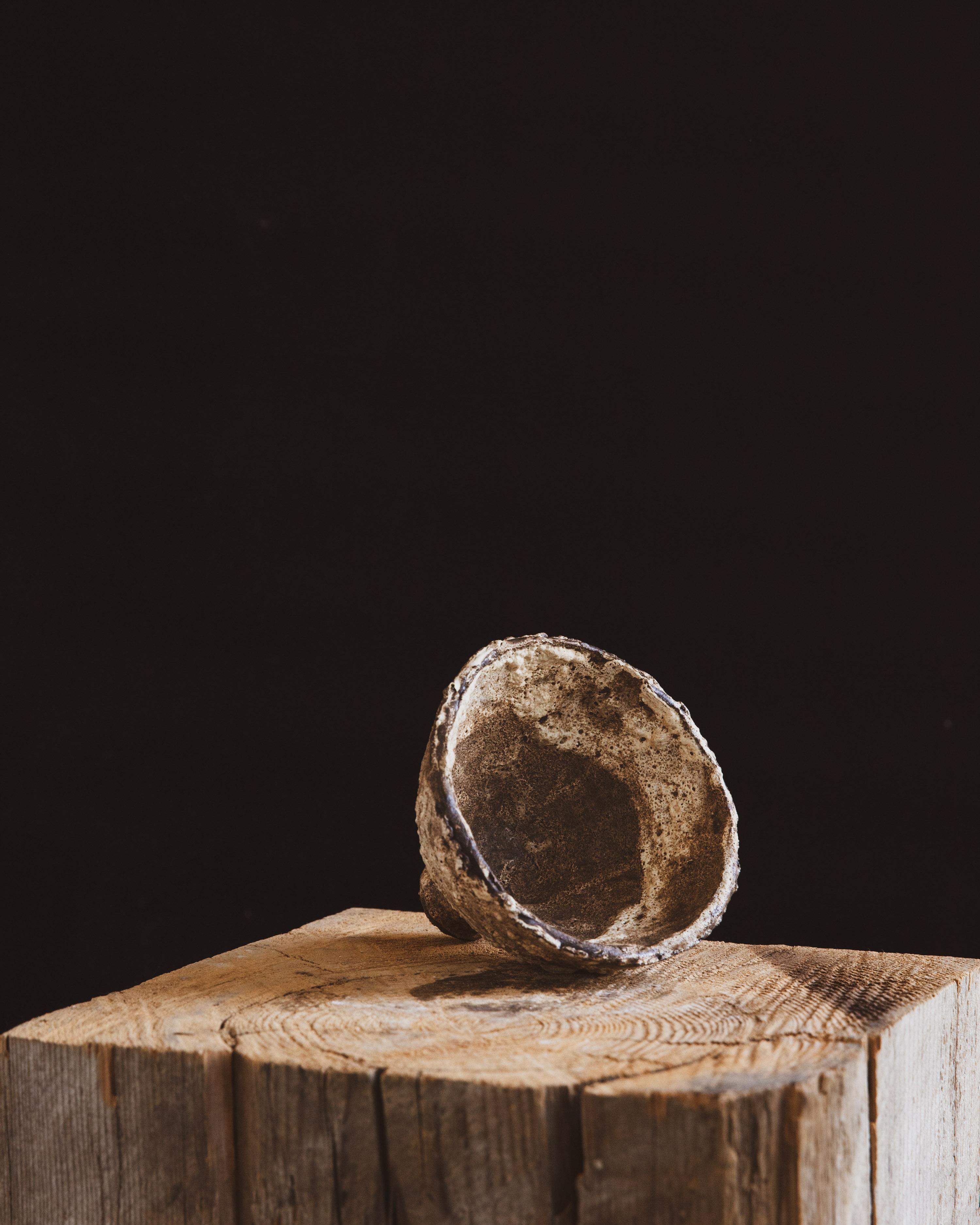 Delicate yet grounded, this hand built ceramic compote vessel by New York-based artist Ilona Golovina resembles an artifact unearthed from volcanic soil. Its petite, chalice-like form rests lightly atop a narrow foot, while the textured surface