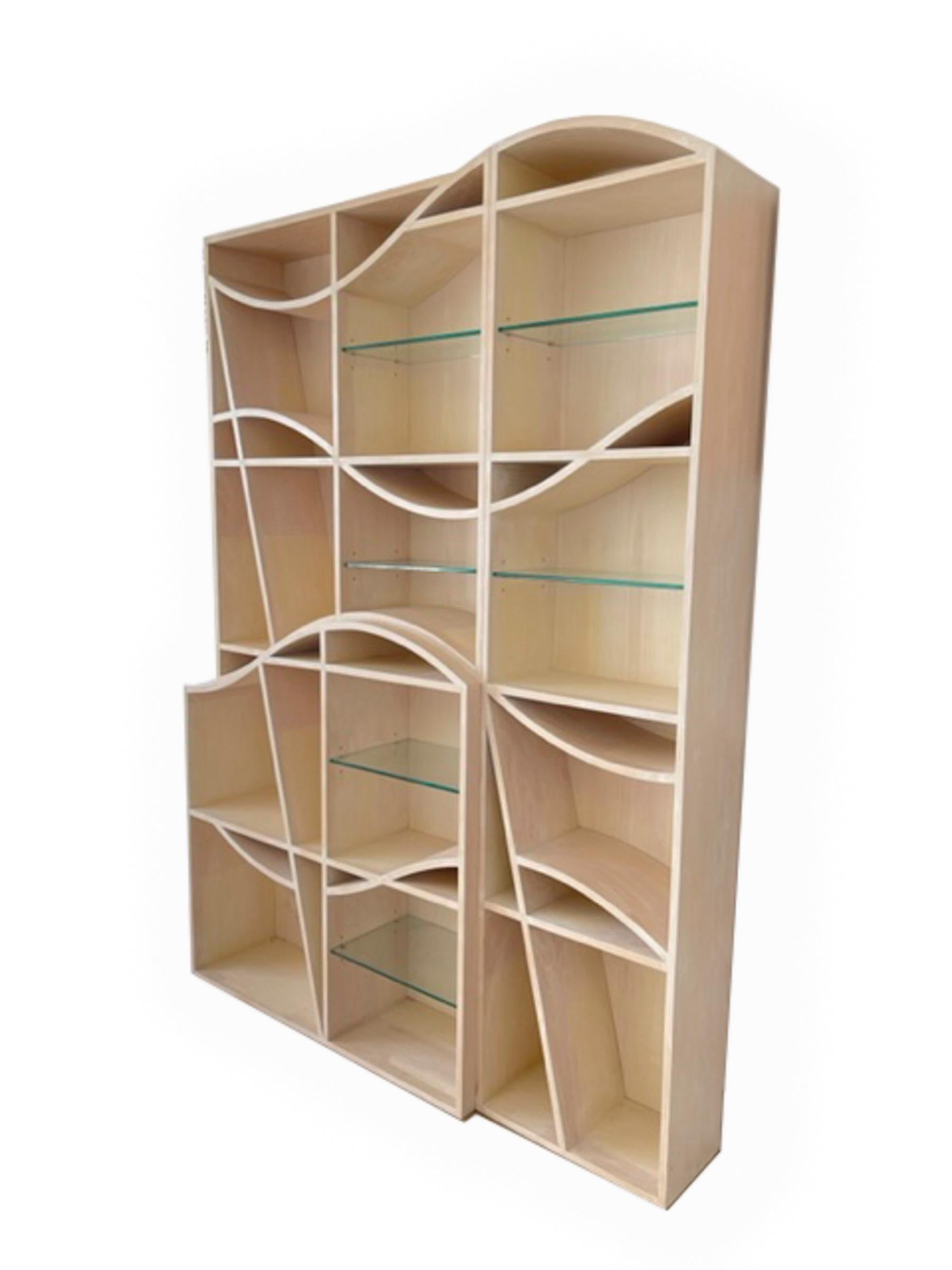 One of a kind bookcase rendered in limed oak with undulating oak shelves and six adjustable glass shelves, numerous uniquely shaped compartments make this piece multifunctional for collections of objet d'art and books. Privately commissioned piece