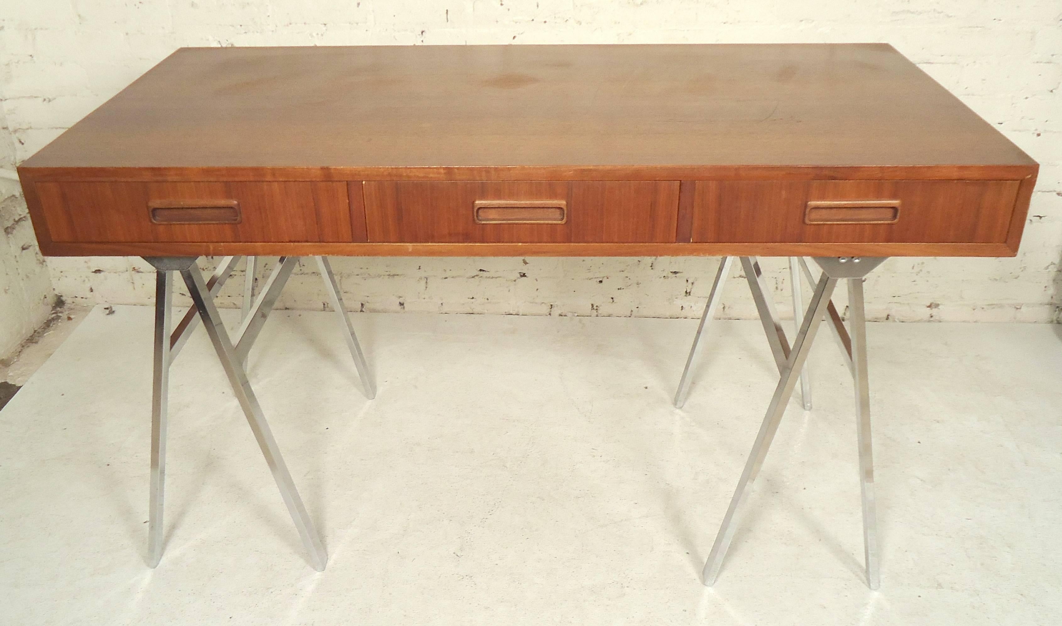 Unique Mid-Century Modern teak flat desk set on polished chrome A-frame bases.

(Please confirm item location - NY or NJ - with dealer).
  