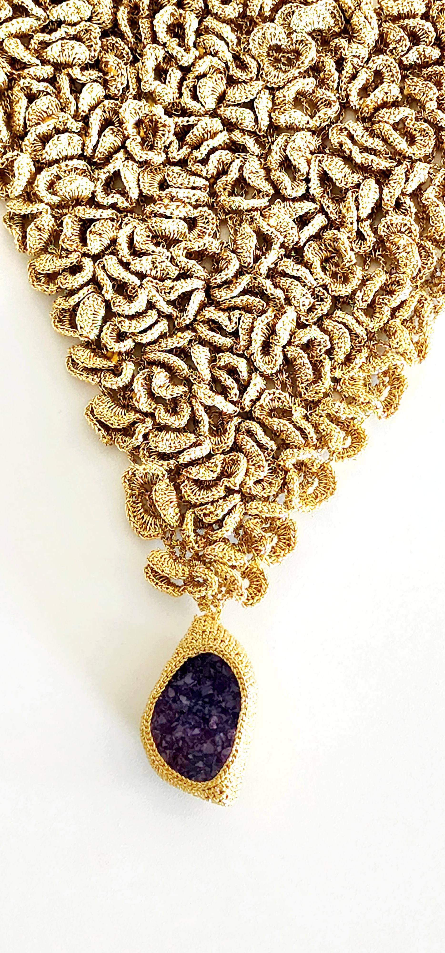 Beautiful, handmade crochet, one of a kind, designer necklace. I call it a 3 dimentional scarf necklace. It is light and bery eye catching. I added a beautiful druze Amethyst stone to enhance its regal effect. It is crochet with a golden smooth