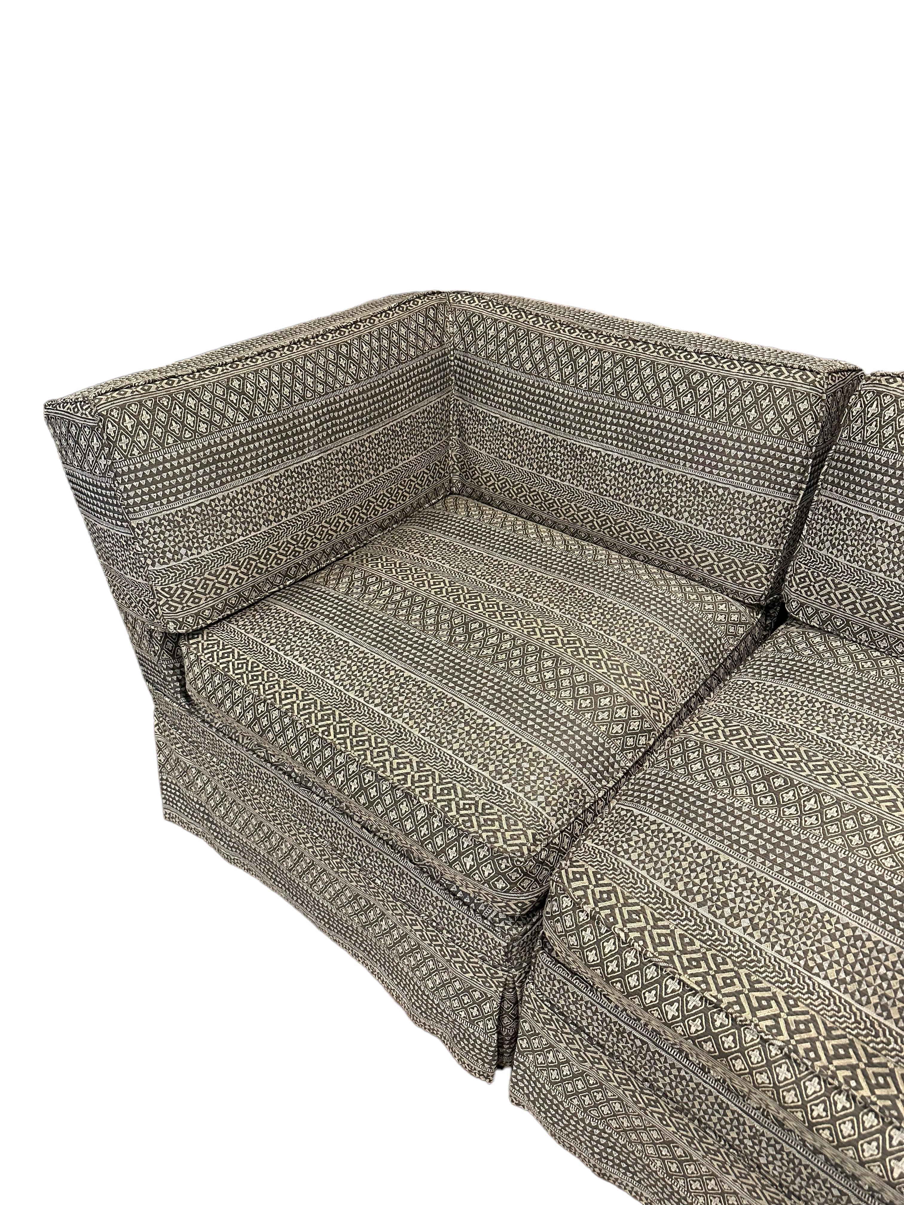 An exceptional two-piece upholstered loveseat by Donghia, a true testament to luxury and style. Crafted with meticulous attention to detail, this loveseat features a slip-covered design that exudes elegance and versatility. The unique woven