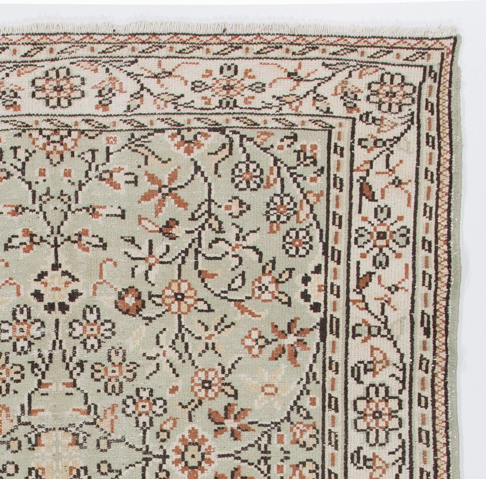 This vintage handmade Turkish area rug measures: 6.2 x 9 ft
It was hand knotted in the 1960s and features an all-over floral design.
Low wool pile on finely woven cotton foundation.
Sturdy and can be used on a high traffic area, suitable for both
