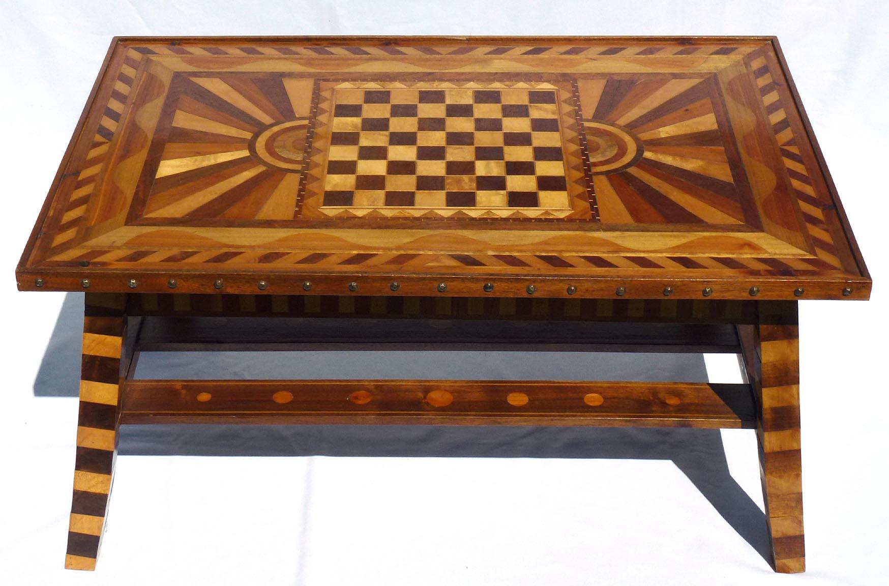 This is an outstanding marquetry game table. The design and workmanship are beautiful. The top has a checkerboard in the center, with a pieced double border. This is flanked by two sunbursts, a wave pattern, and then a triple border. The sides,