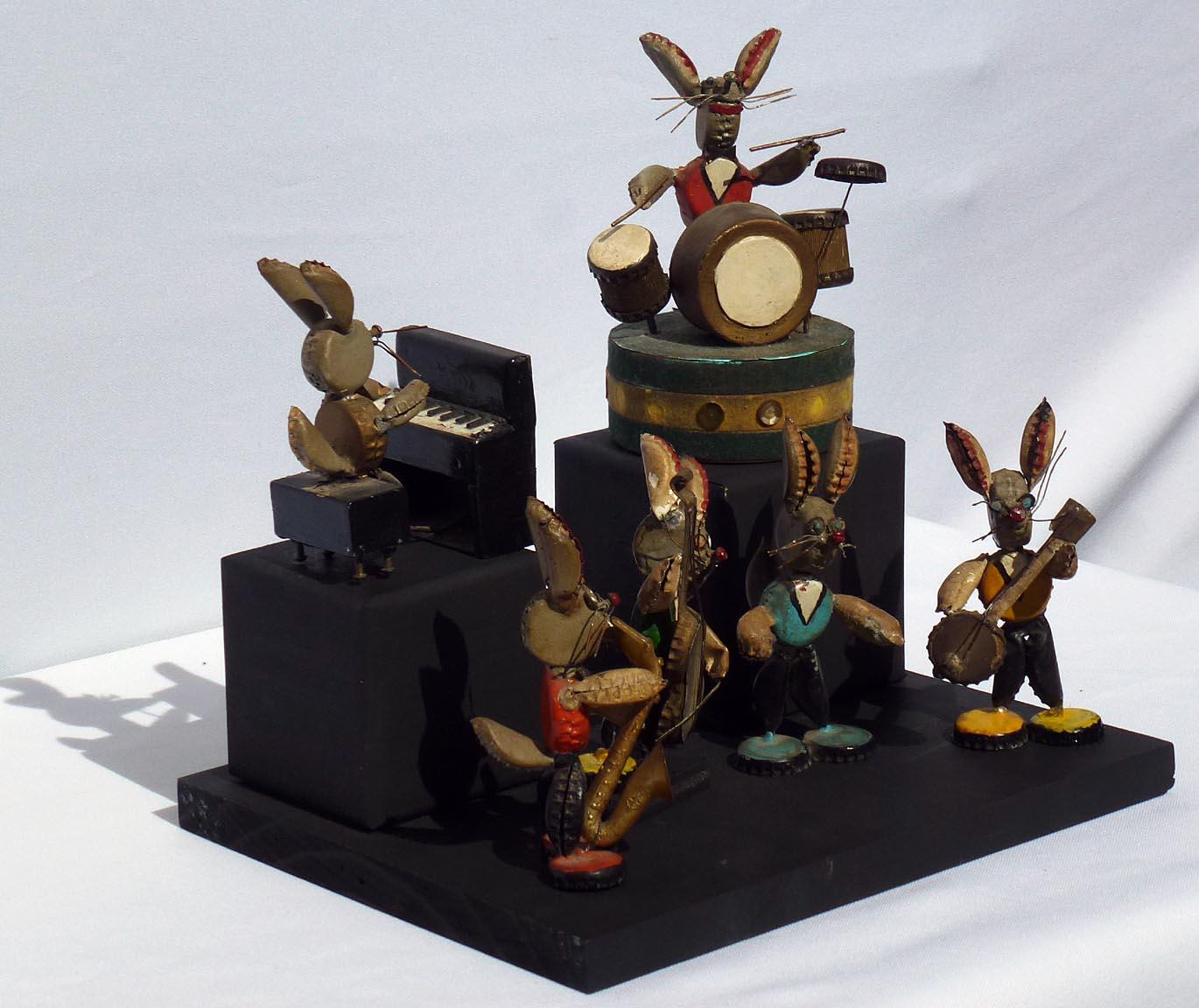 This is a wonderfully folky set of rabbit musicians made from bottle caps and found objects. There is a piano, drums, banjo, base, saxophone, and one rabbit who is singing and/or directing. The ears, tails, arms, and legs are bottle caps folded in