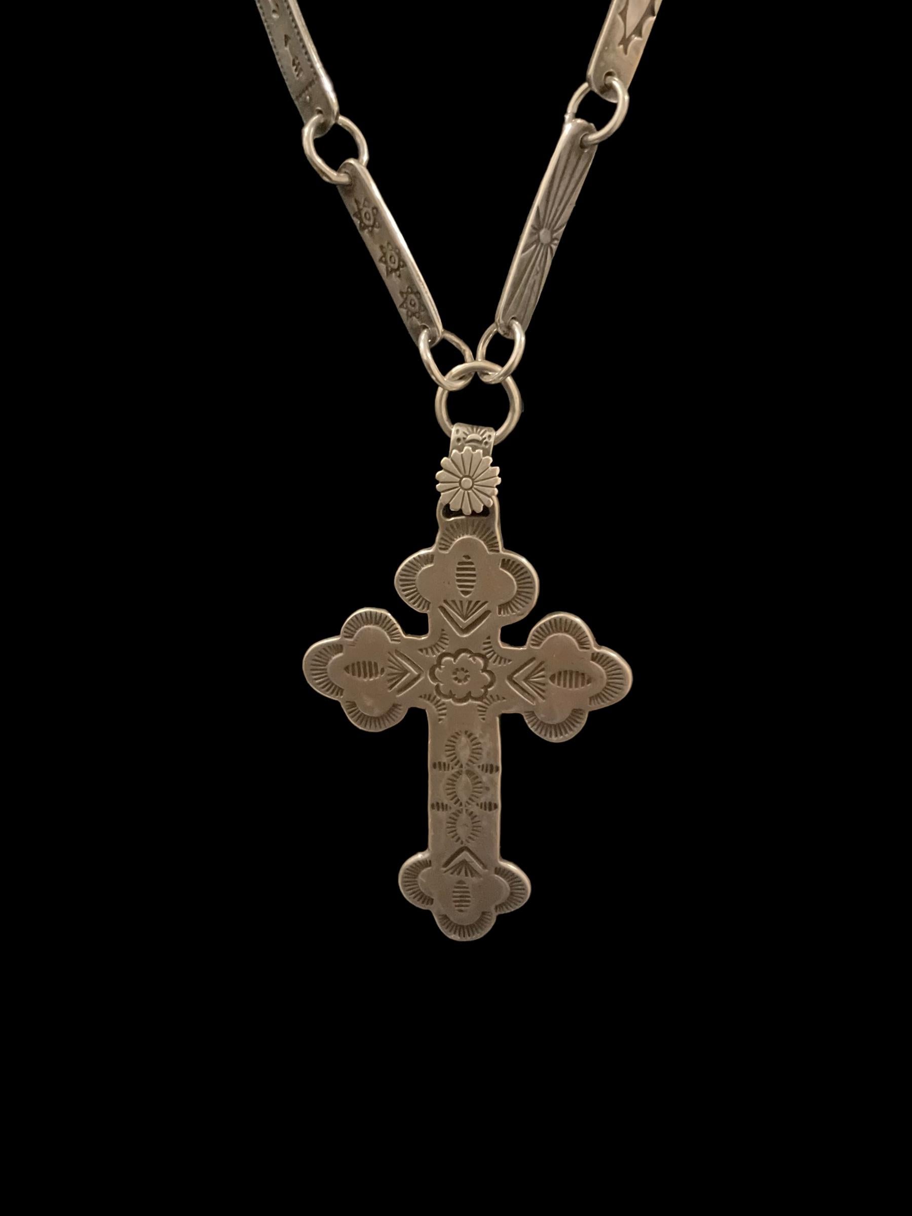 This Fred Harvey Native American sterling silver cross necklace was made circa 1920. Each side of each chain link has a stamped Navajo symbol: sunbursts, snakes, arrows, stars, fish and others. It's quintessential Fred Harvey. I guarantee it'll