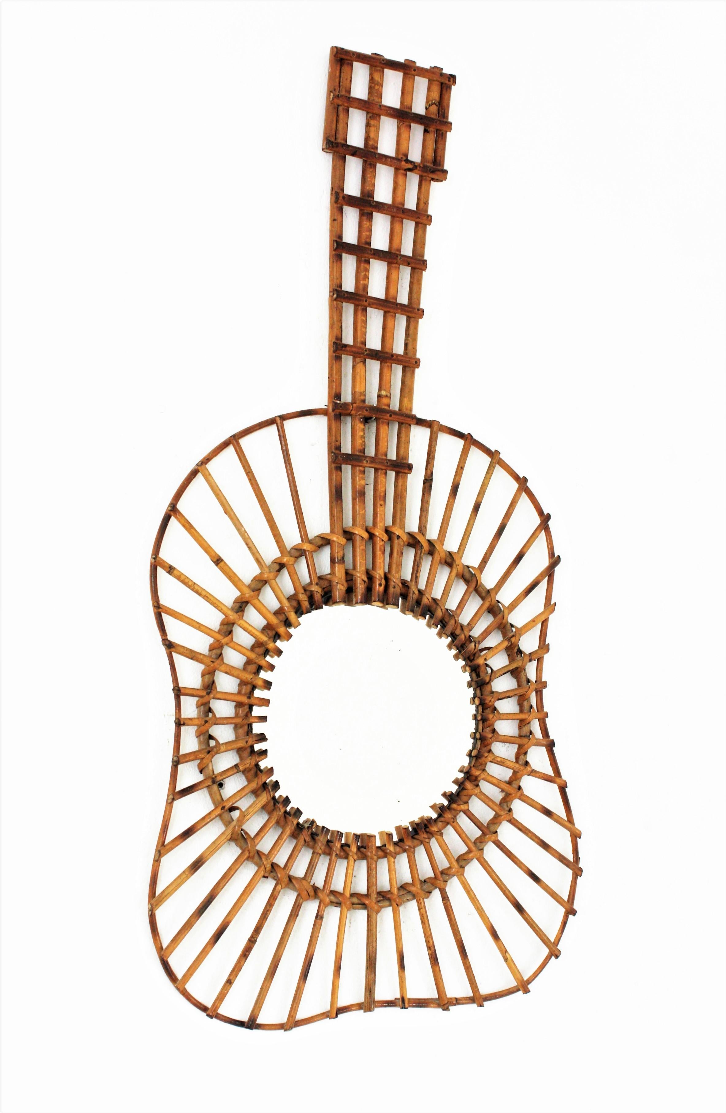Unusual handcrafted rattan guitar wall mirror, France, 1950s.
This spectacular mirror has a design combining the Midcentury style and the natural taste from the French Riviera.
Excellent vintage condition.
Eye-catching placed alone but gorgeous
