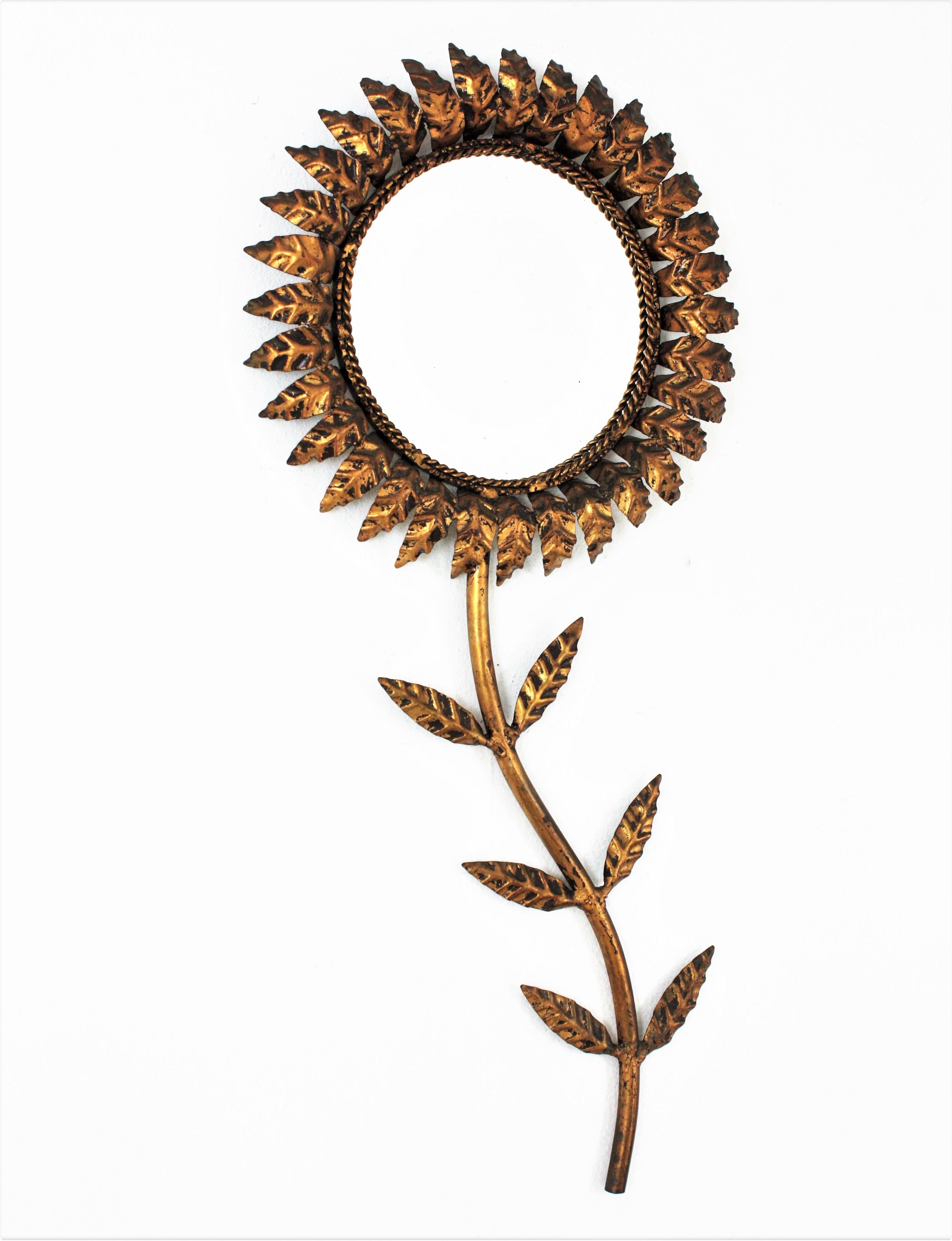One of a kind  gilt iron sunflower wall mirror / wall sculpture, France, 1950s.
This spectacular wall mirror has an eye-catching flower shaped design with 
Handcrafted in gilt iron. It has a nice patina showing its original gold leaf