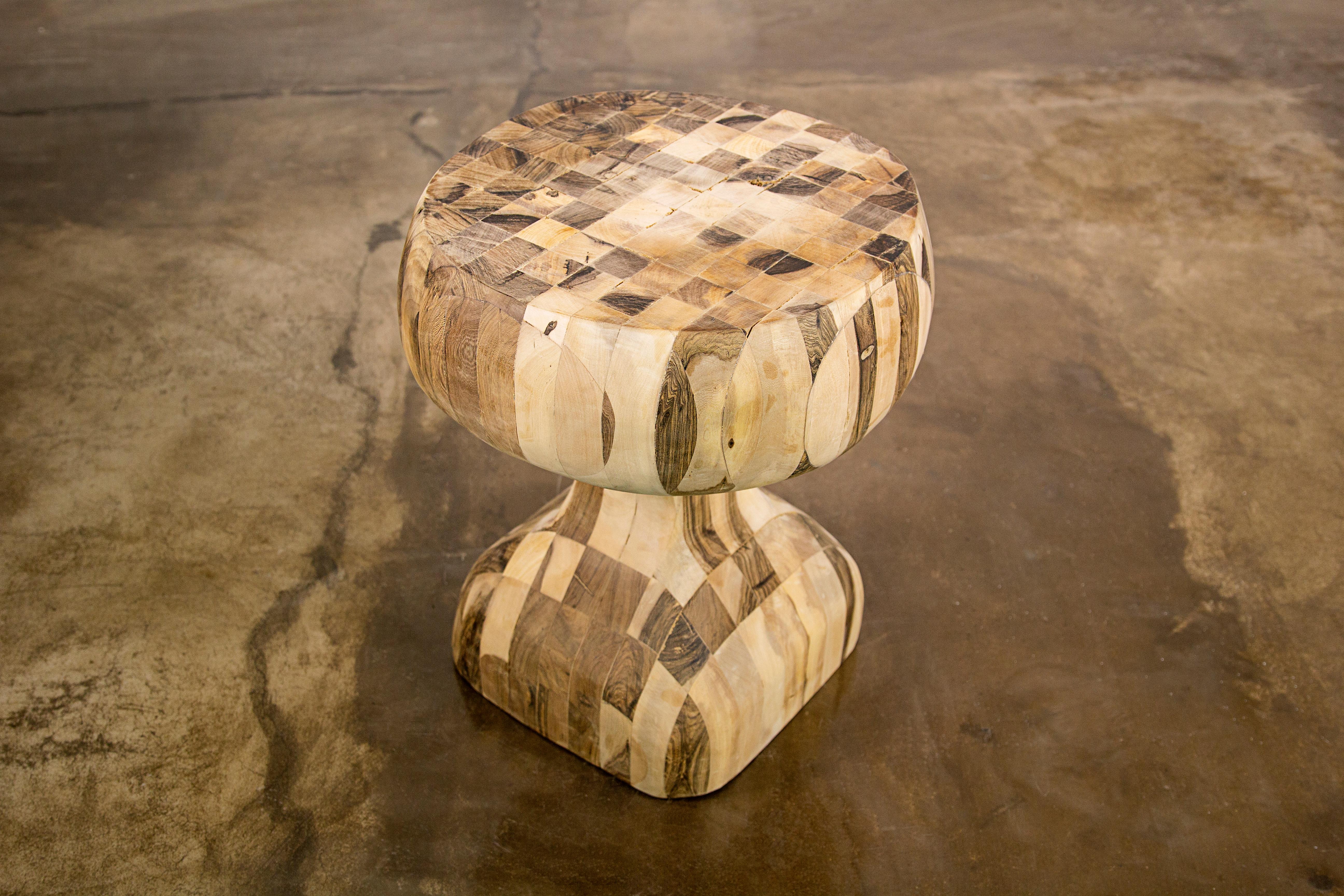 This one-of-a-kind solid wood side table is an experiment from Costantini based on their popular Caliz side table. We glued together dozens of solid pieces of wood, then carved it with a chainsaw, then hand sanded it and lightly finished it to