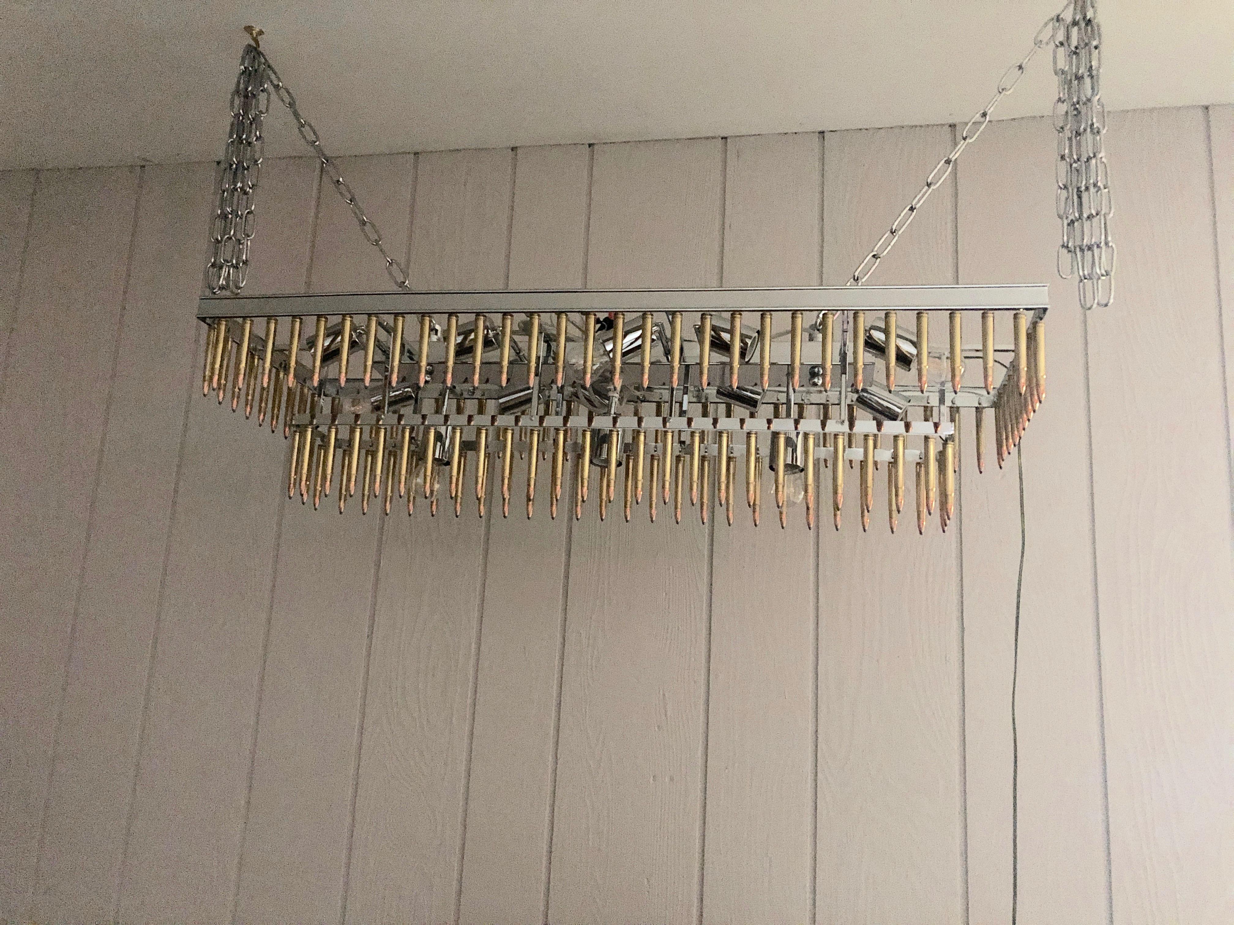 Local Princeton artisan handcrafts one of a kind chandeliers from old salvaged light fixtures which are transformed to contemporary pieces adorned with copper bullets. This is a large rectangular two tier creation with 8 sockets.