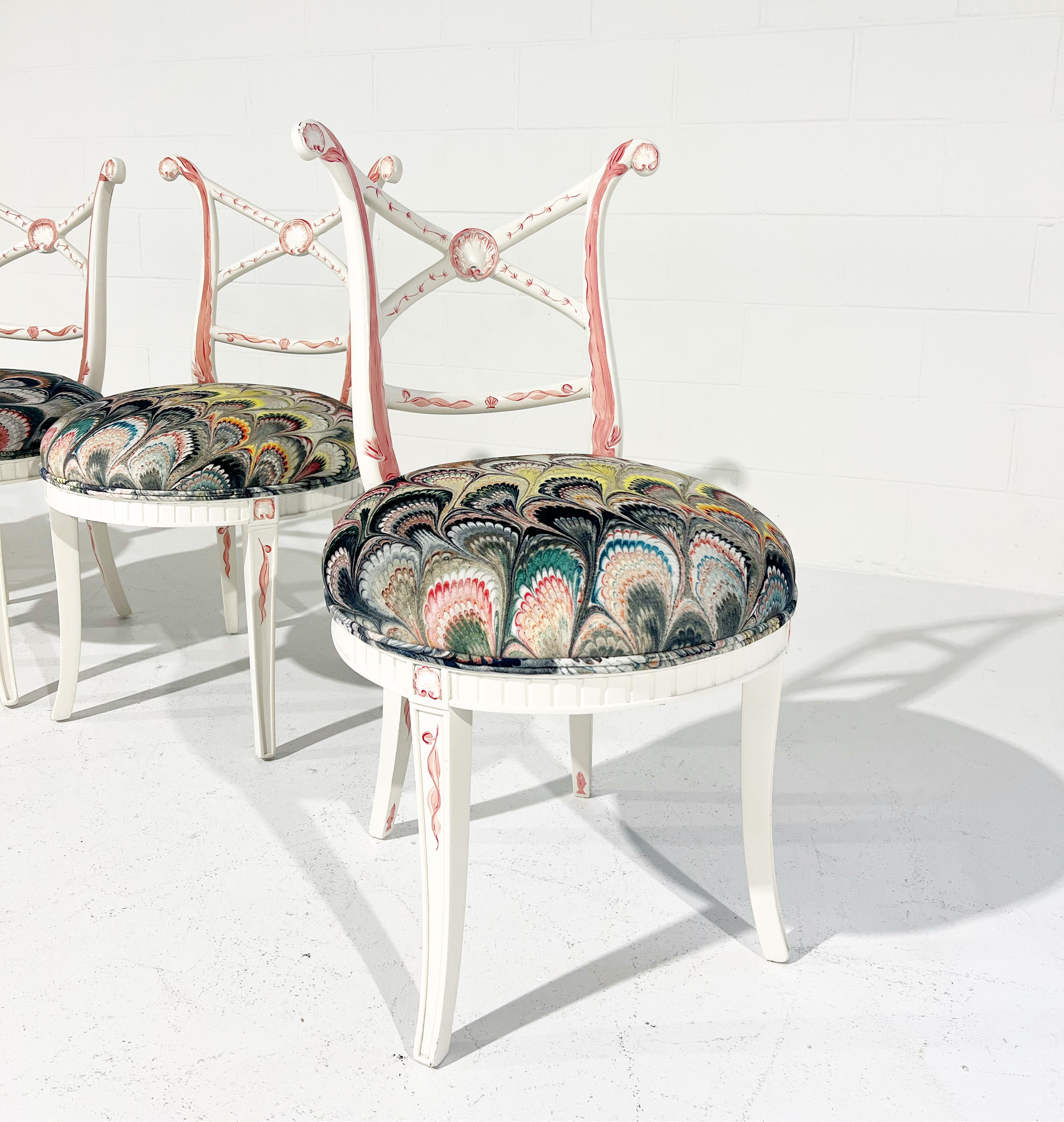 A charming set of 4 chairs in the Hollywood Regency style. Each chair was first stripped and painted a beautiful ivory color, the perfect backdrop for artist Maggie Robertson. Inspired by the chair's design and details, Maggie hand-painted imagery