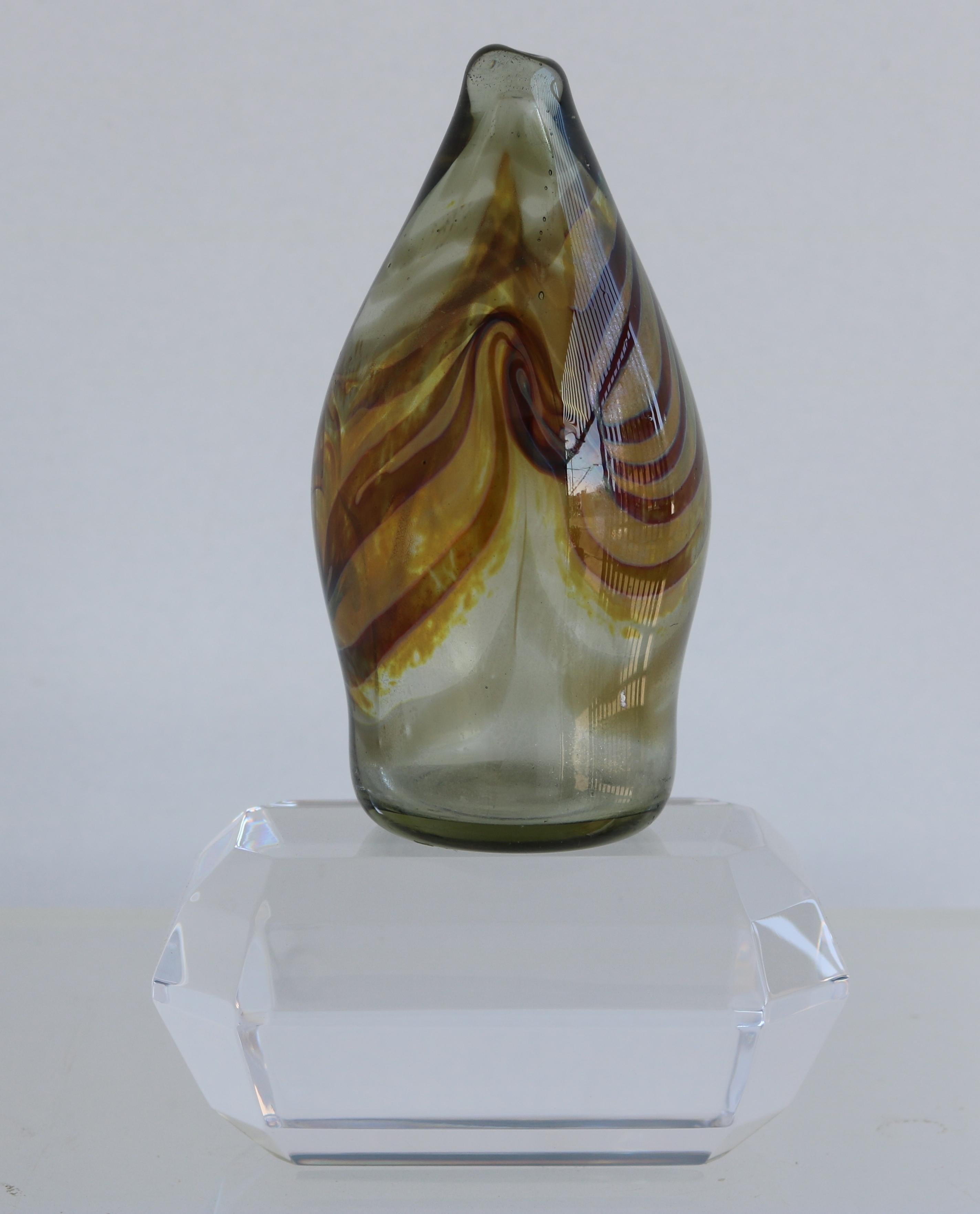 This one-of-a-kind handblown glass piece features yellow caramel-colored stripes on a clear form. The piece is shaped like a vase, yet the top has no opening. Displayed on a Lucite stand.
The dimensions with of the glass sculpture without the base
